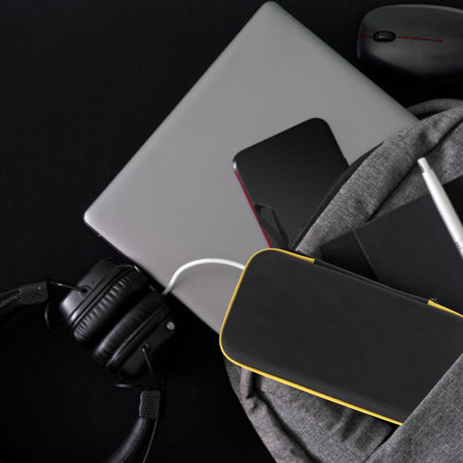 Laptop, Telefon und Hülle in einer Tasche. Kopfhörer und ein Stift sind ebenfalls sichtbar.