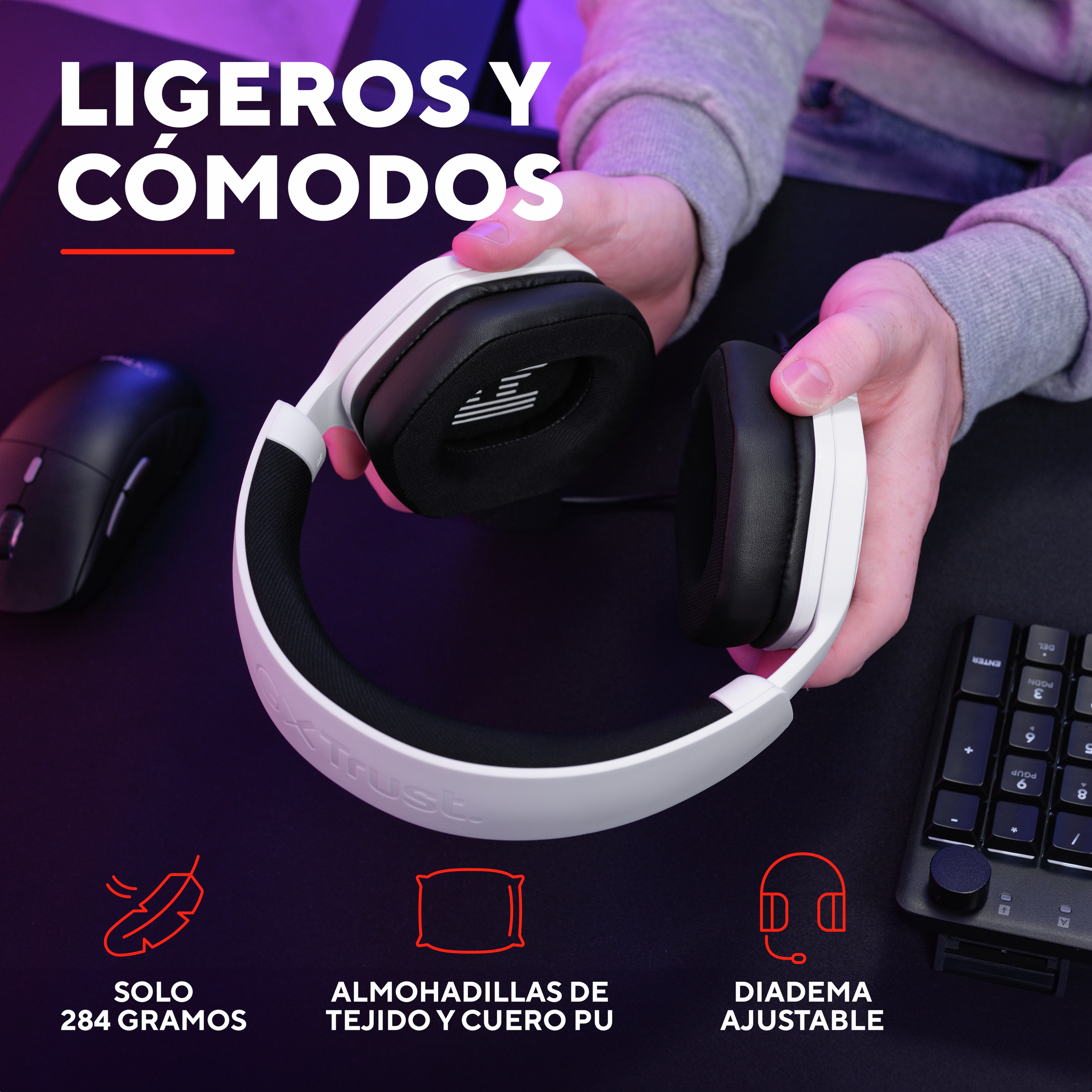 Białe słuchawki z czarnymi nausznikami, trzymane przez osobę. Tekst brzmi 'Ligeros y cómodos'.