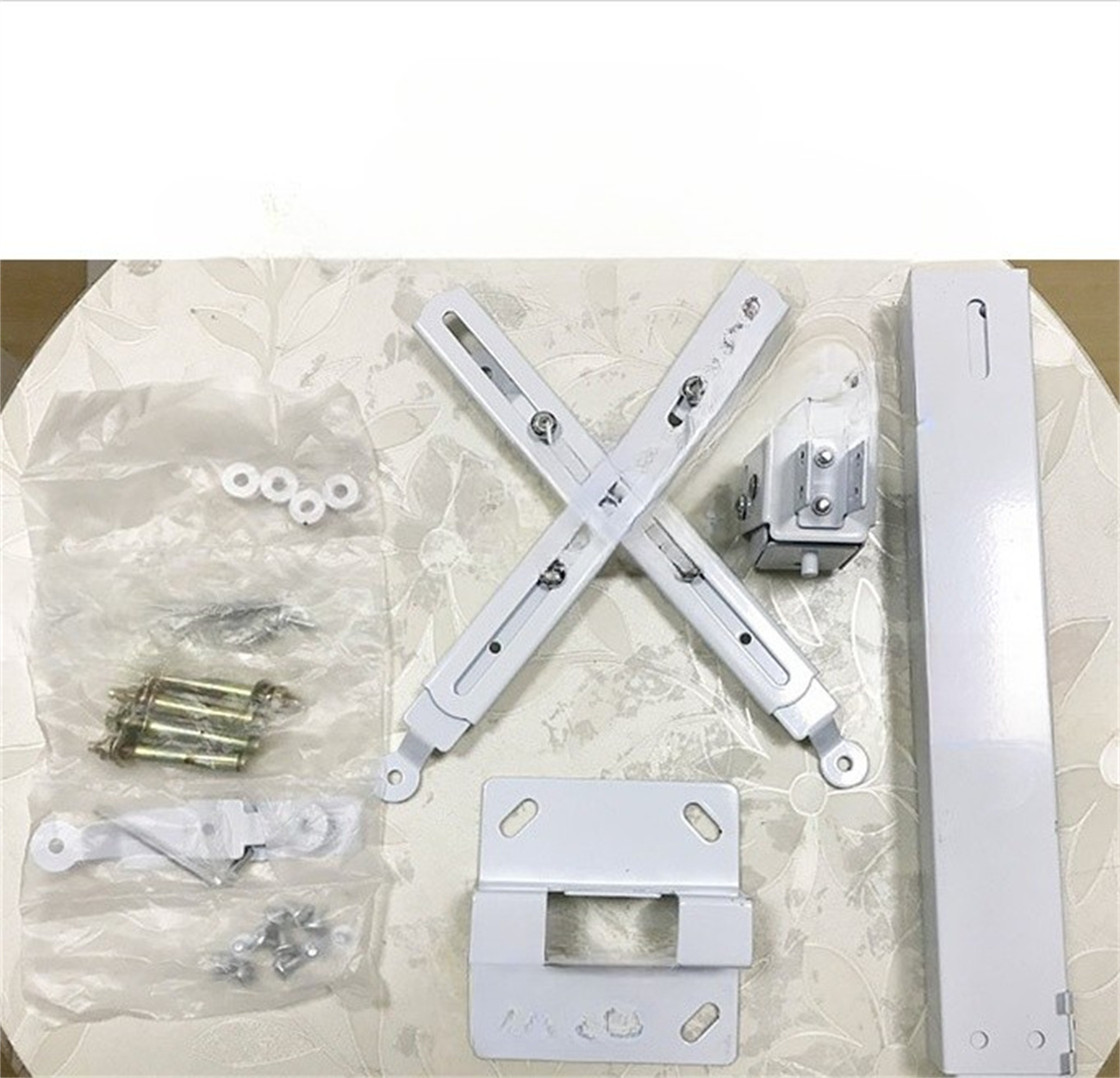 Weiße Halterungen und Hardware für einen Projektor. Verschiedene Komponenten liegen auf einem Tisch.