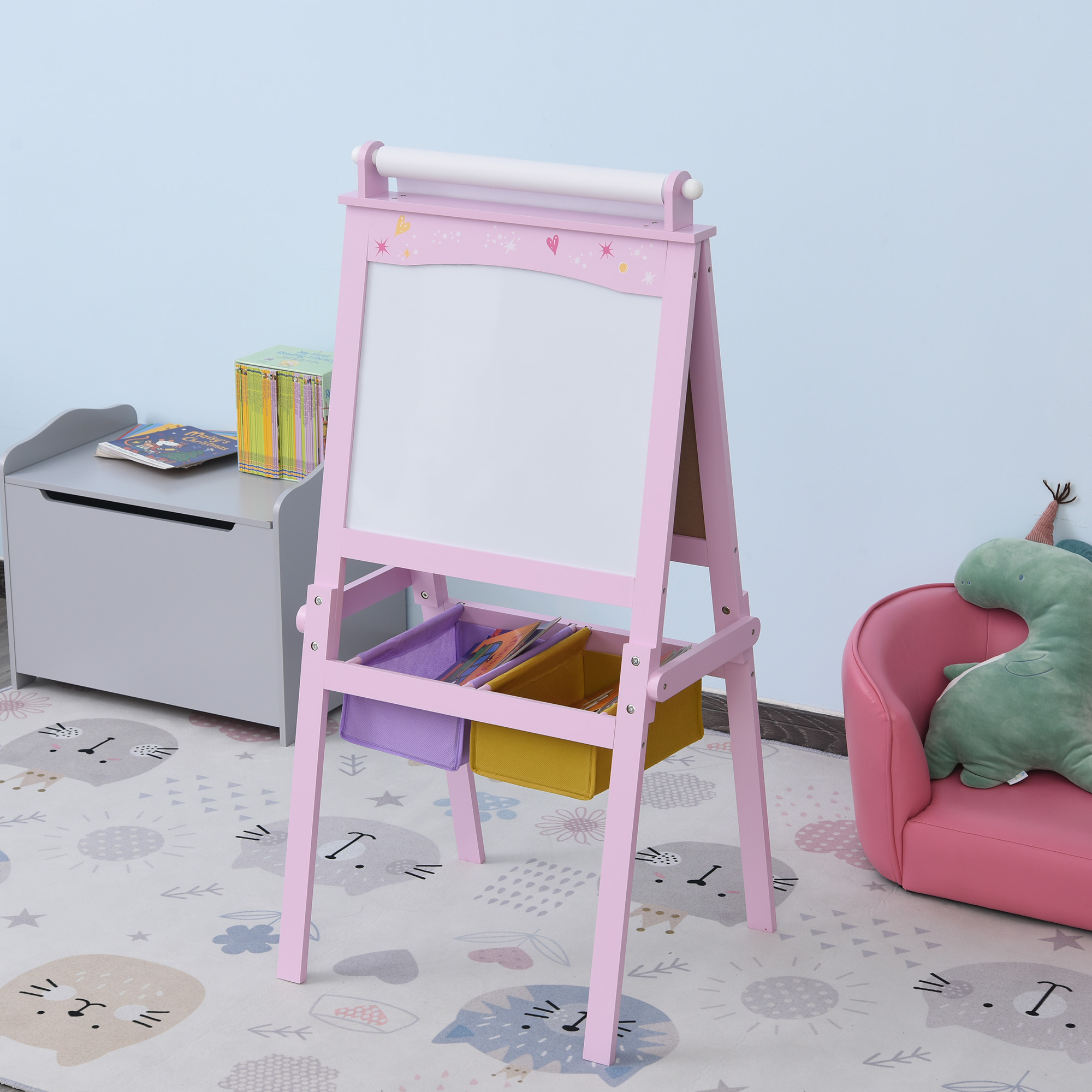Un cavalletto rosa con lavagna bianca e cestini, in una sala giochi.