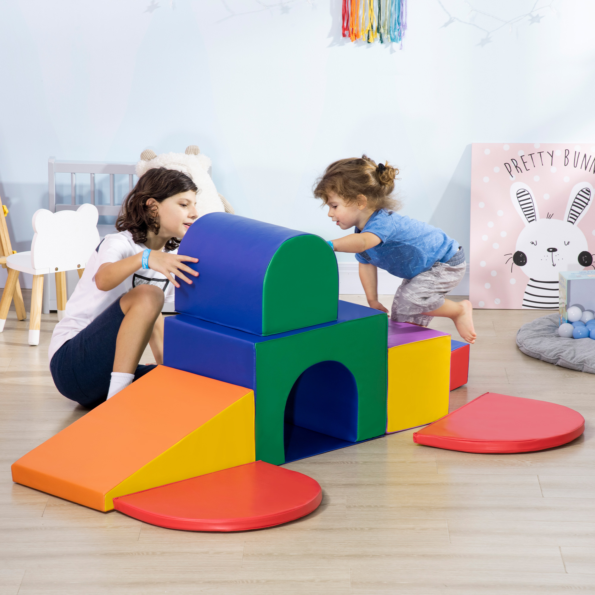 Dos niños jugando con bloques de espuma de colores en una habitación.
