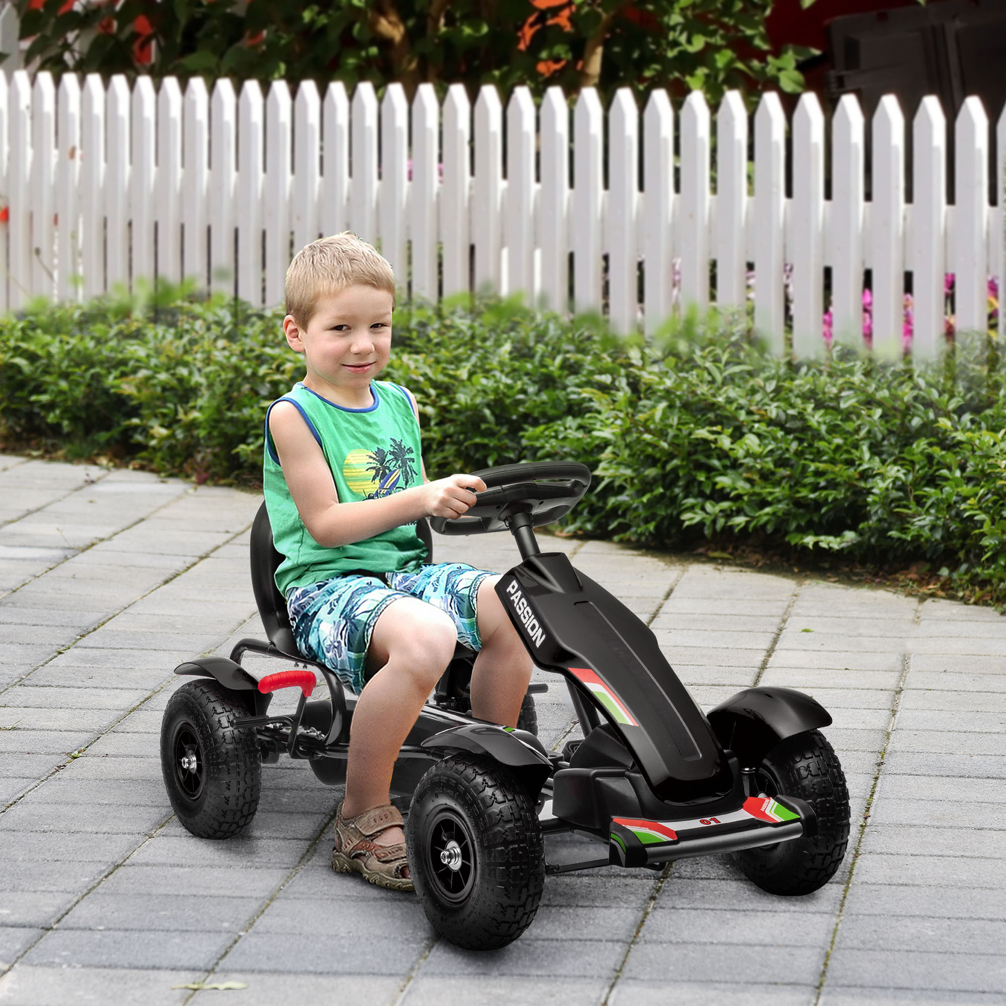 Un ragazzino con una maglietta verde e pantaloncini blu guida un go-kart nero.