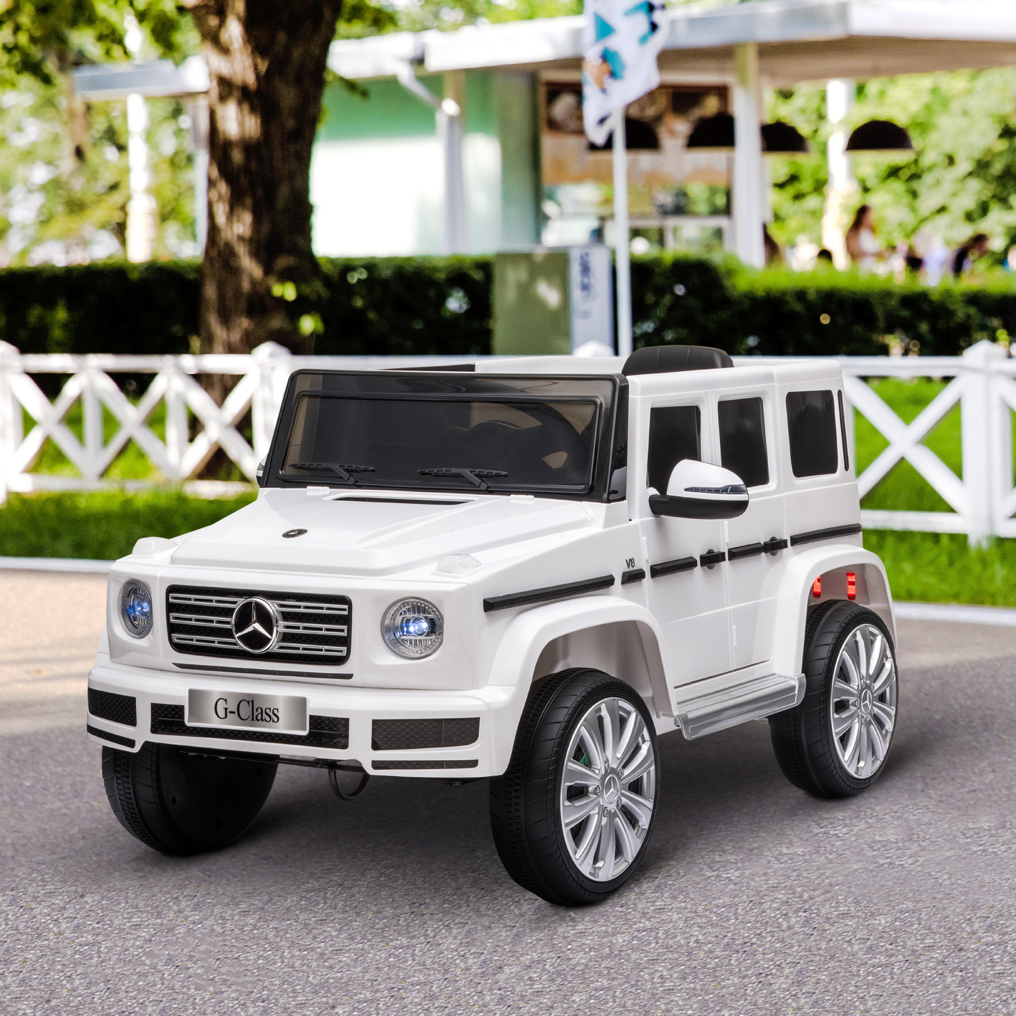 SUV Mercedes-Benz G-Class de juguete blanco sobre superficie gris.