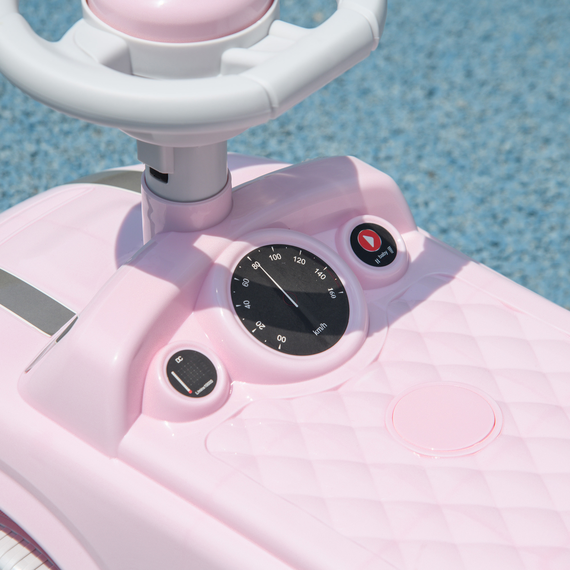 Tablero de un coche de juguete rosa con velocímetro y volante.