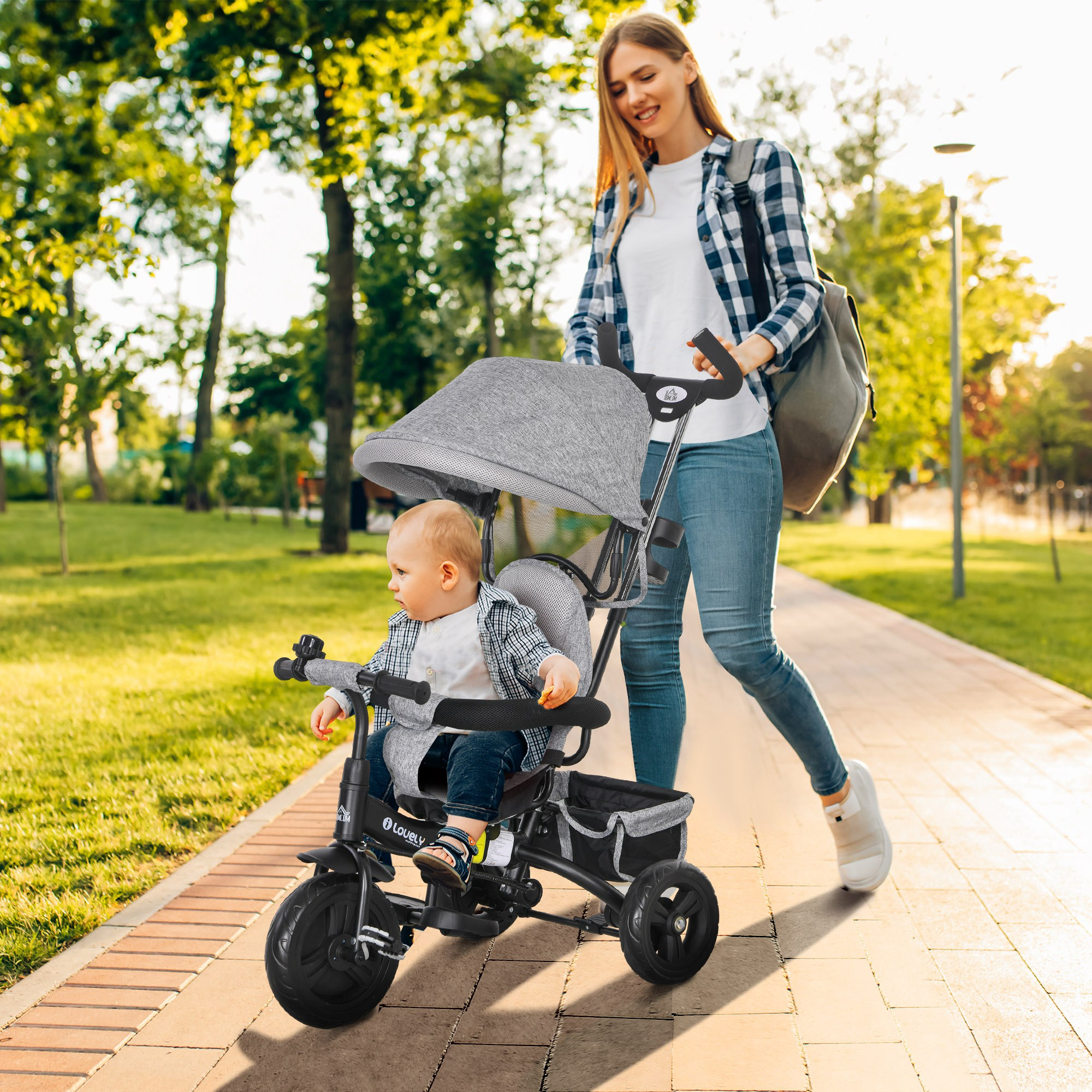 Una donna che spinge un bambino in un passeggino su un sentiero pavimentato.