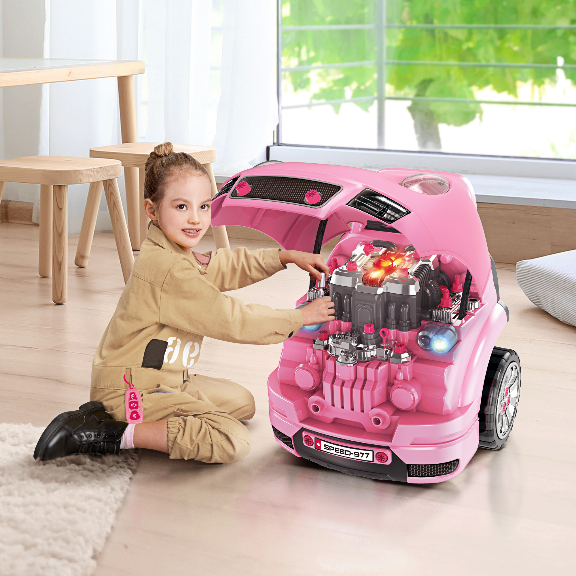 Una niña jugando con un coche de juguete rosa, abriendo el capó.