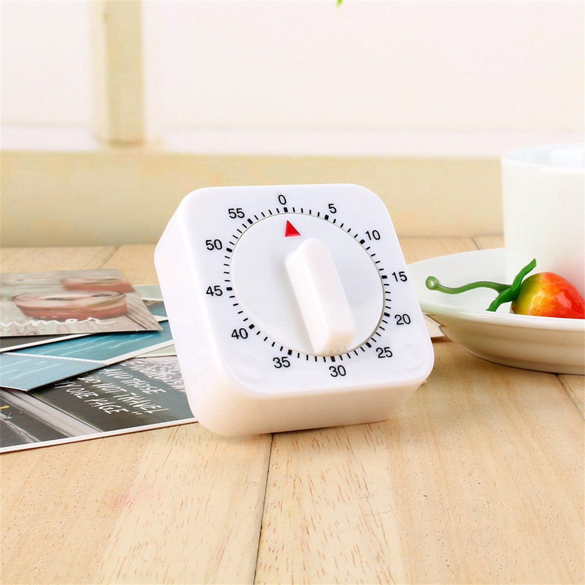 Weißer quadratischer Küchentimer mit roter Anzeige bei Null, auf Holzoberfläche.