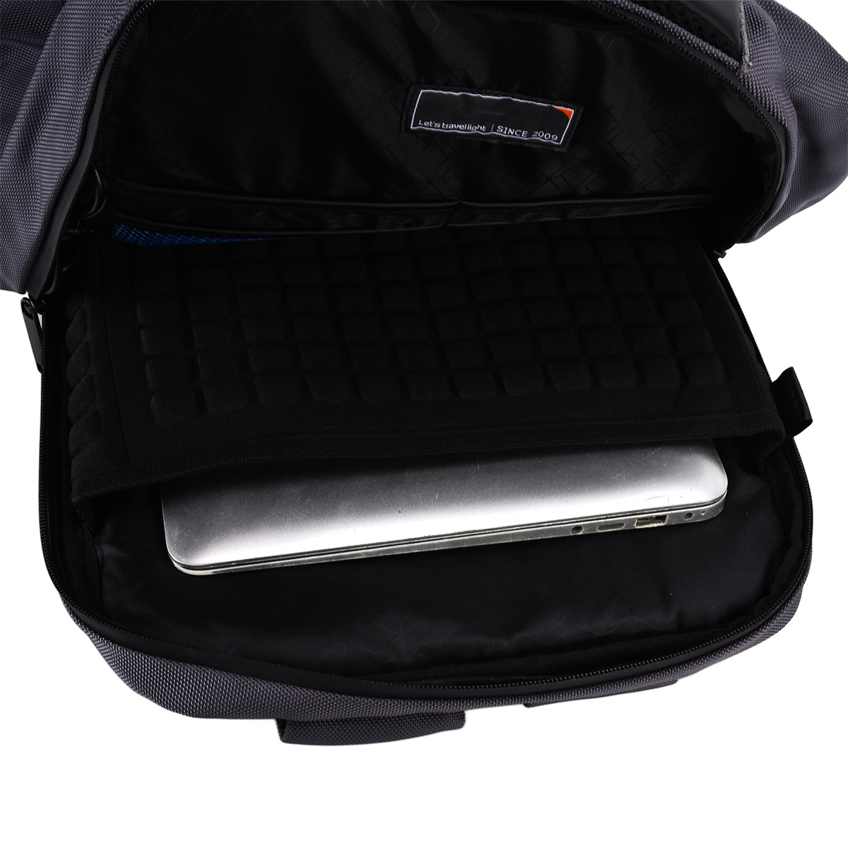 Das Innere eines grauen Rucksacks mit einem Laptop. Enthält einen Laptop und ein schwarzes Fach.