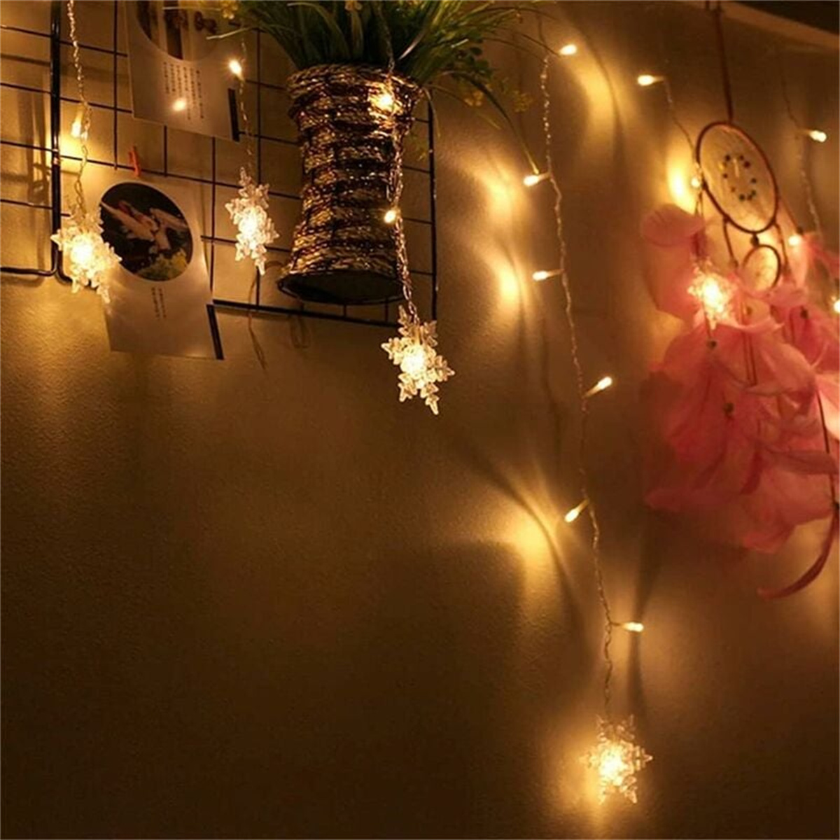 Ein gemütliches Zimmer mit Lichterketten und einem Traumfänger. Eine Pflanze ist im Hintergrund.