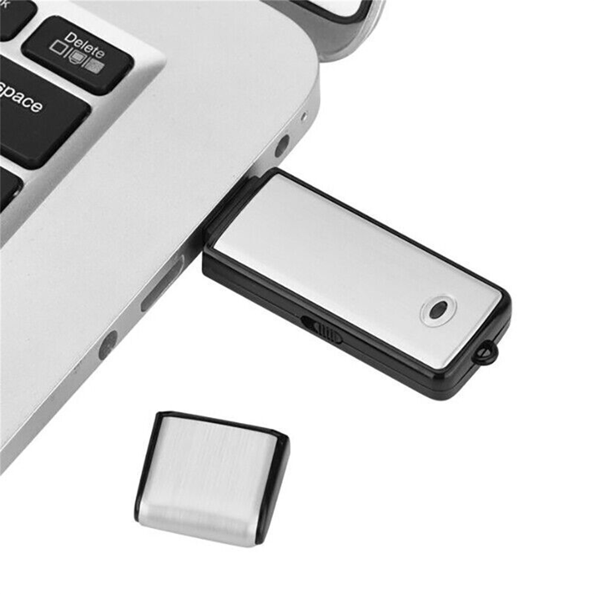 Silberner USB-Stick an einem Laptop angeschlossen und eine abgenommene Kappe.