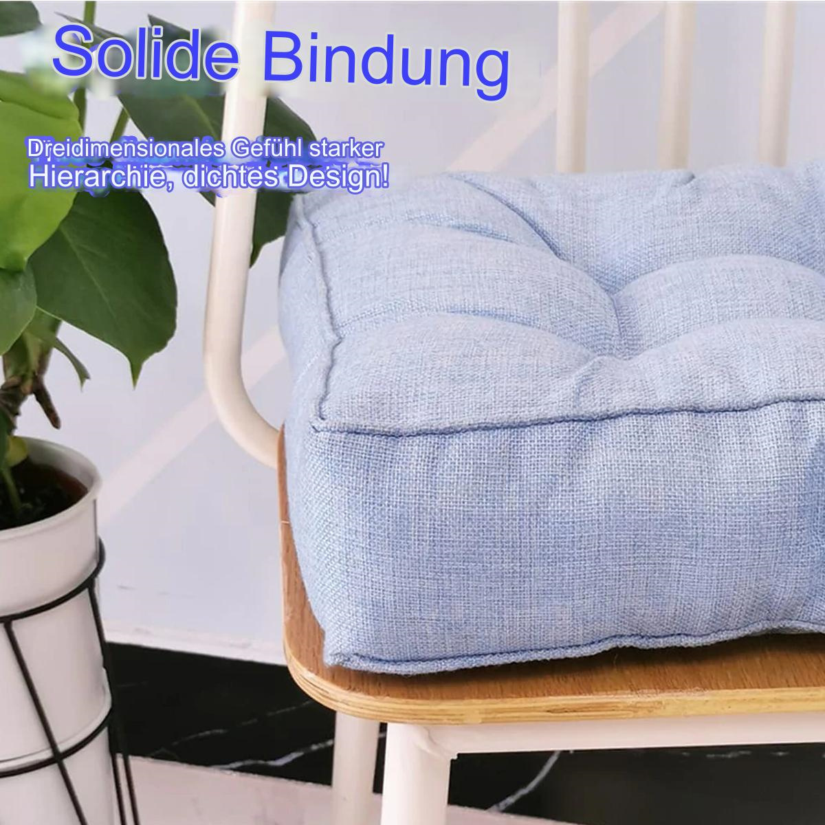 Ein blaues Kissen auf einem Stuhl. Der Stuhl ist weiß und hat einen hölzernen Sitz.