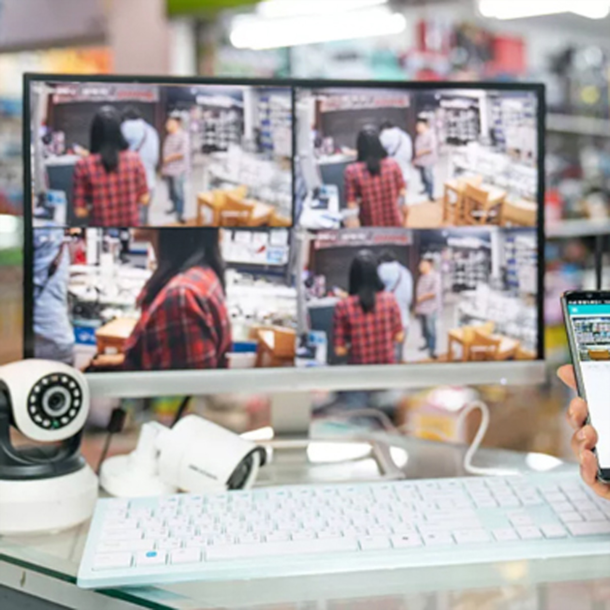 Konfiguracja kamery bezpieczeństwa z wieloma ekranami wyświetlającymi nagrania w środowisku detalicznym.