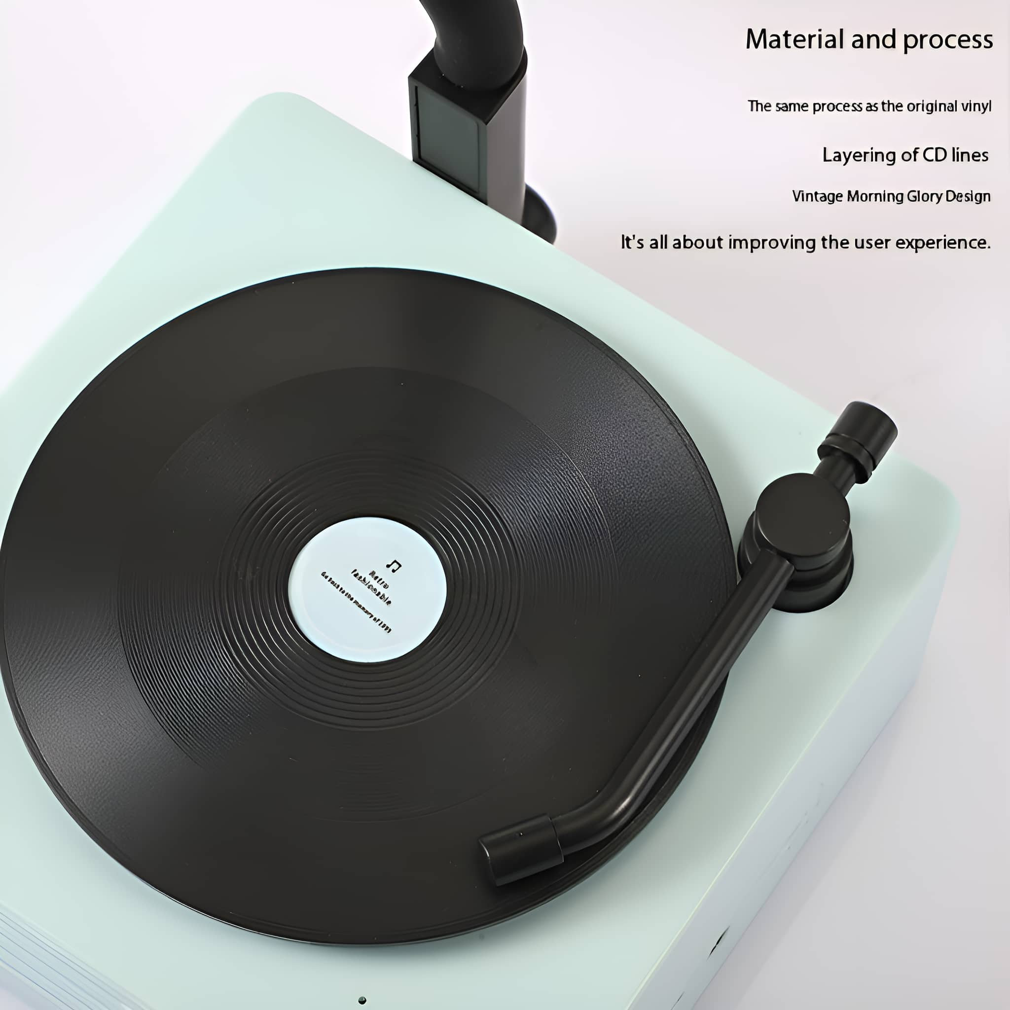 Plattenspieler mit Vinyl, schwarzem Tonarm, hellgrüner Basis und Text über Benutzererfahrung.
