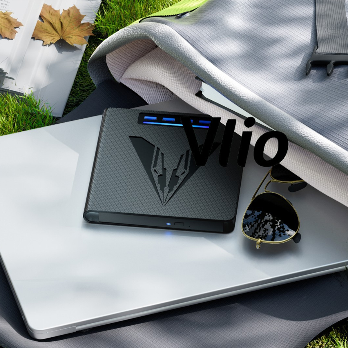Ein Laptop, Sonnenbrille und Gerät mit "Vlio" auf einer Matte.