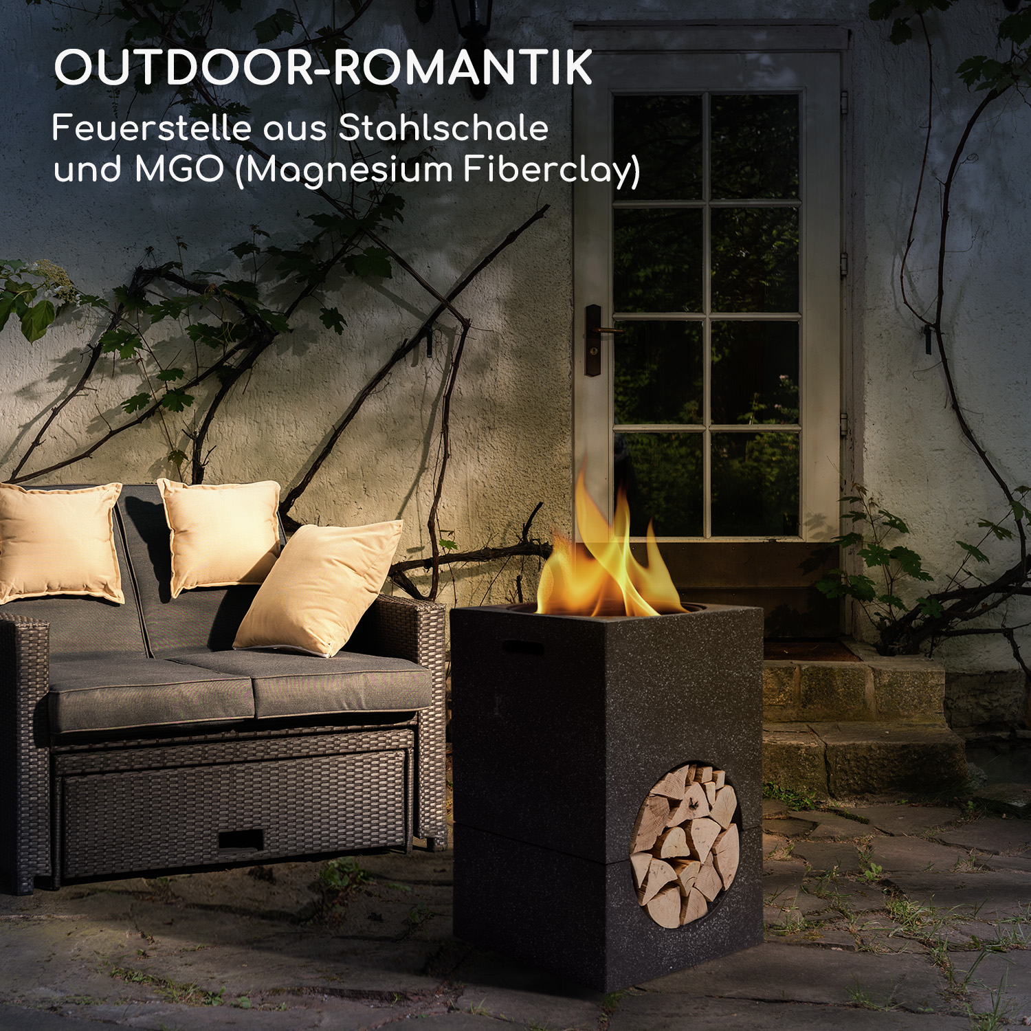 Eine schwarze Feuerstelle mit einem darin brennenden Feuer, mit einem Sofa und Kissen im Hintergrund.