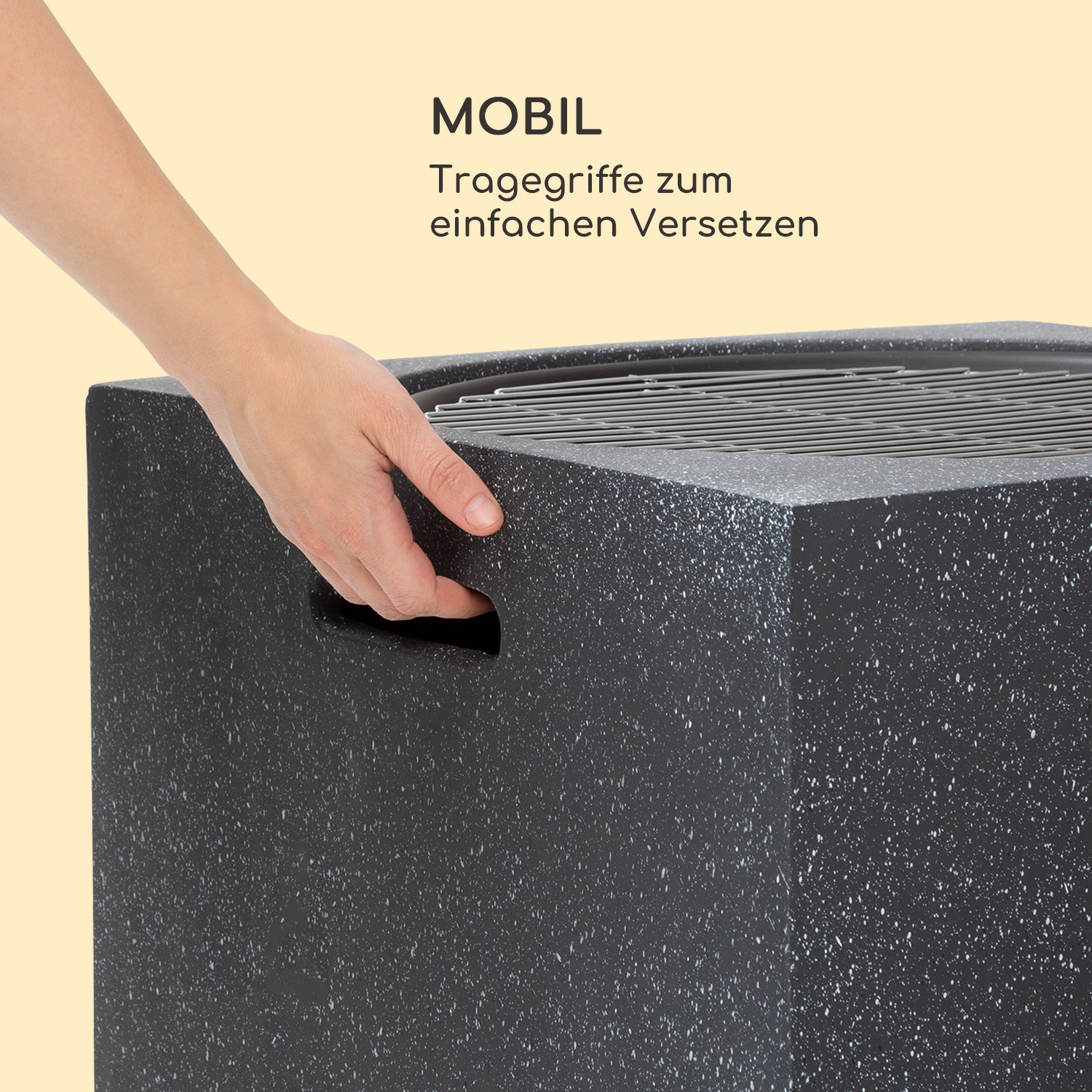 Ein schwarzer und grauer Outdoor-Propangas-Feuerplatz. Eine Hand berührt den Griff, Text sagt 'MOBIL'.