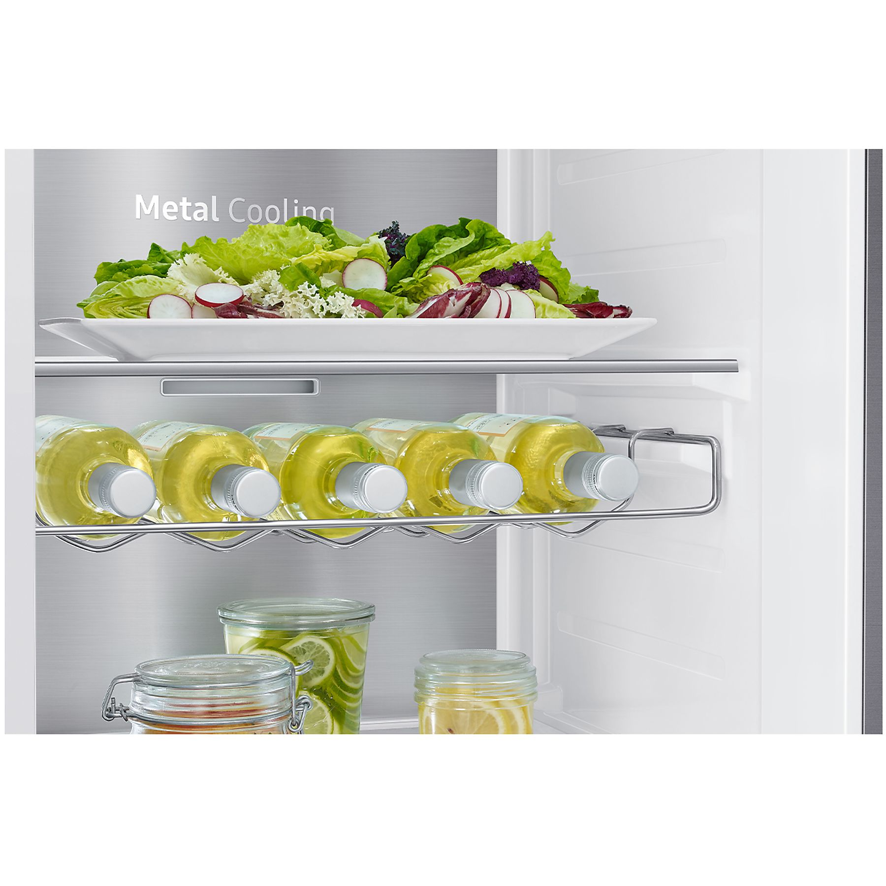 Interno del frigorifero. Insalata, bottiglie di vino e vasetti sono visibili sugli scaffali.