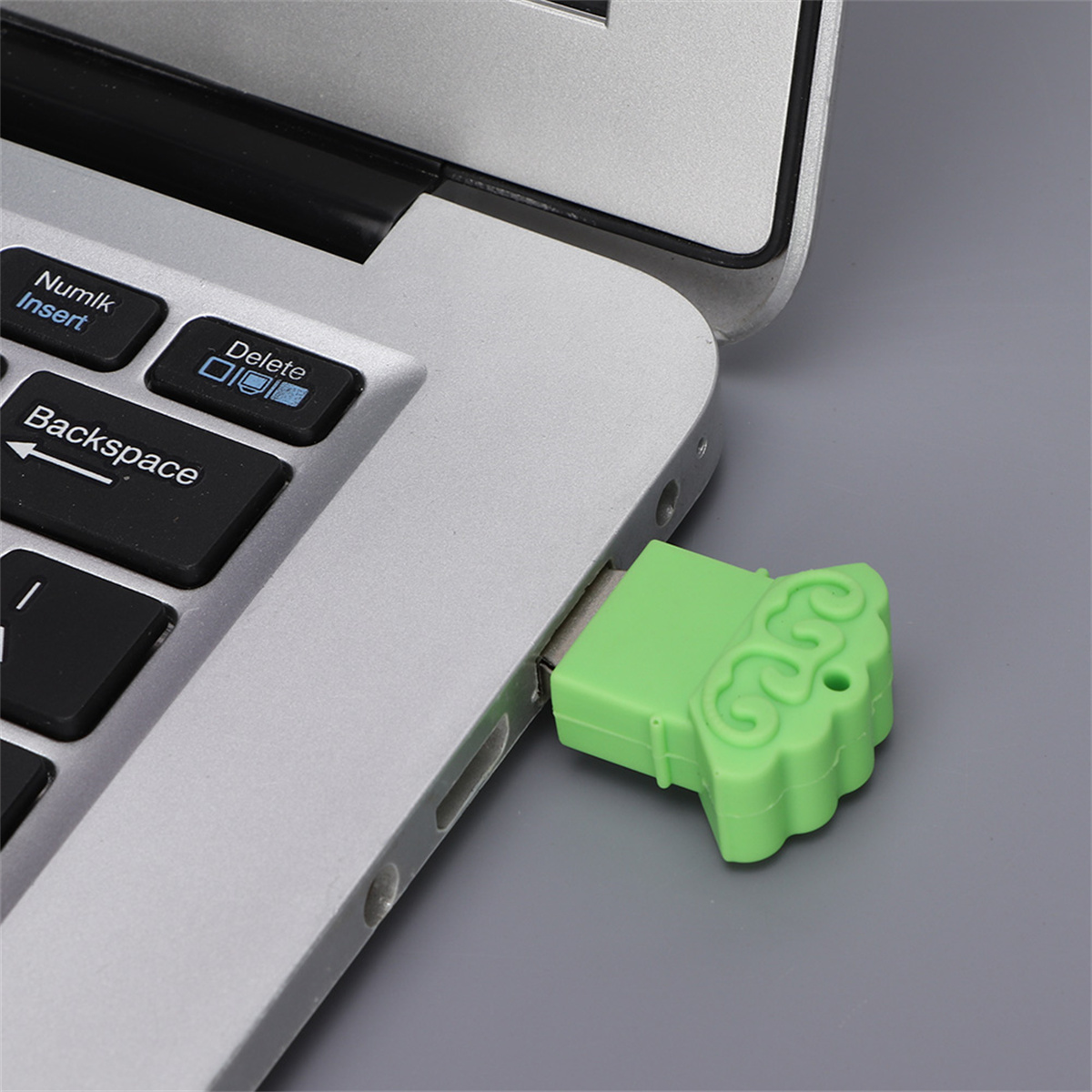 Ein grüner USB-Stick, der an einen Laptop angeschlossen ist, mit sichtbarer Tastatur.