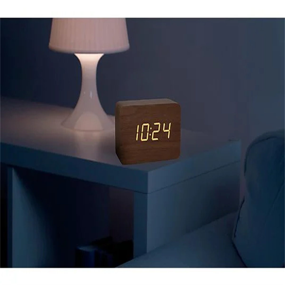 Digitaluhr aus Holz, zeigt 10:24, auf weißem Tisch.