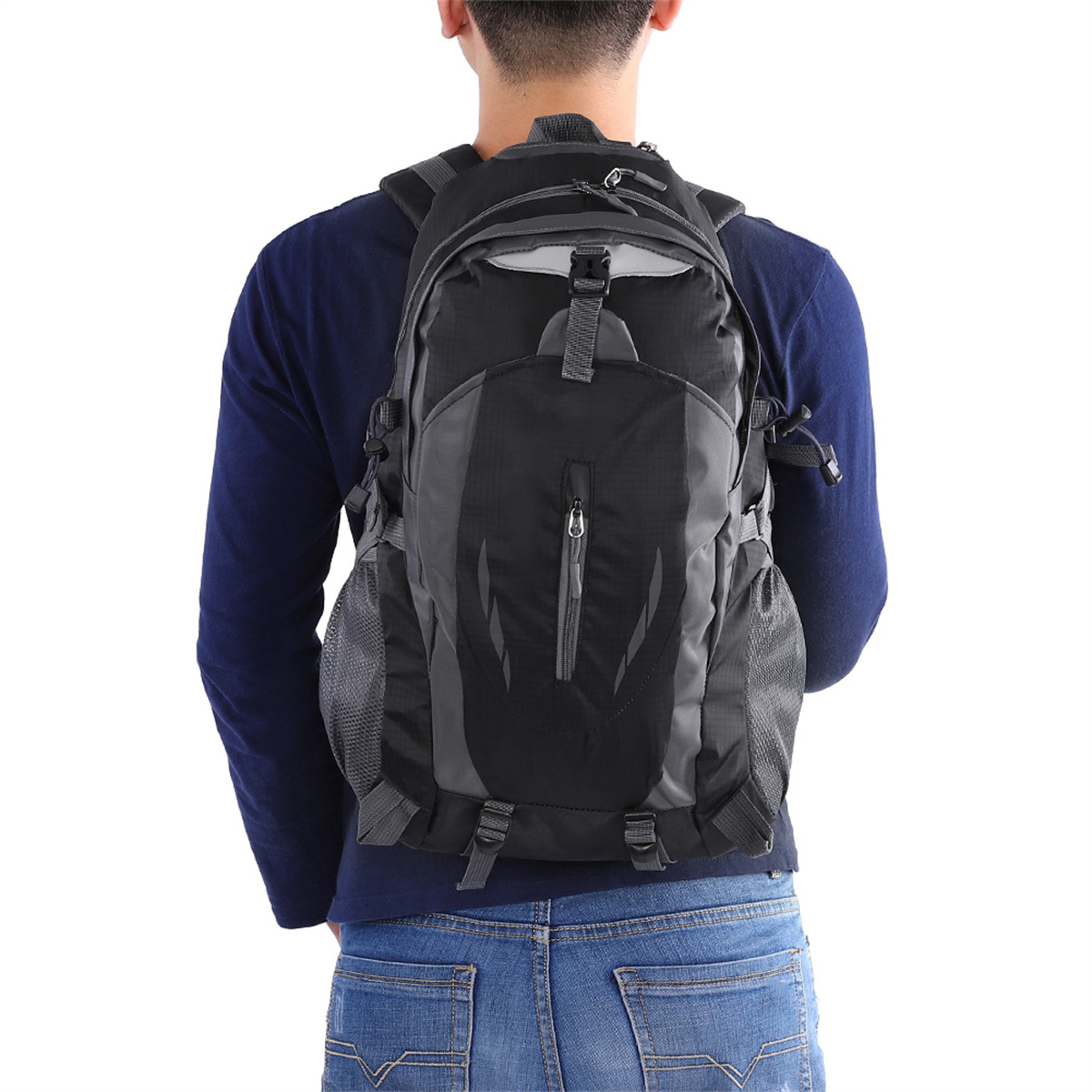 Mann trägt einen schwarz-grauen Rucksack mit blauer Jeans.