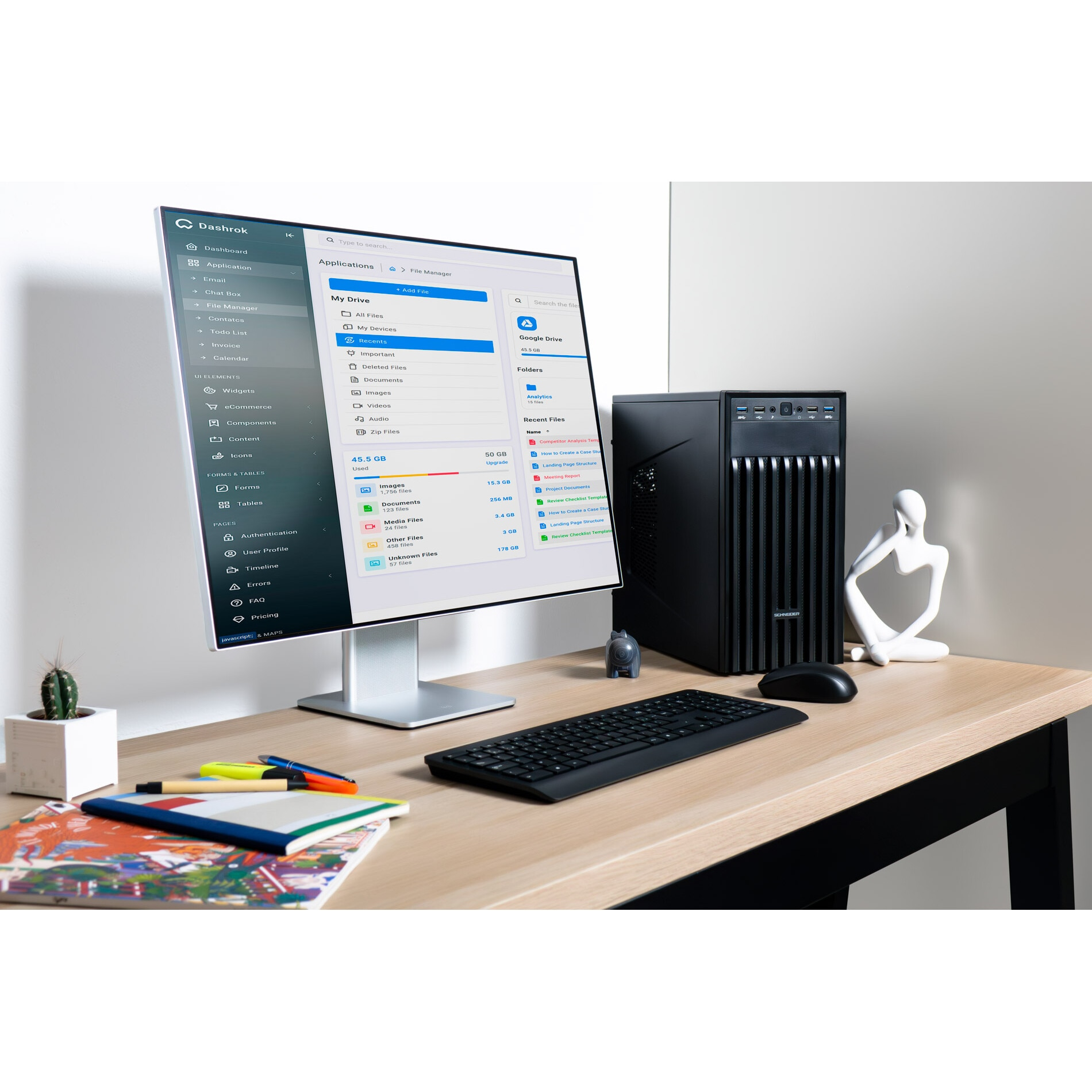 Konfiguracja komputera z monitorem, procesorem, klawiaturą, myszą i akcesoriami biurowymi. Drewniany stół.