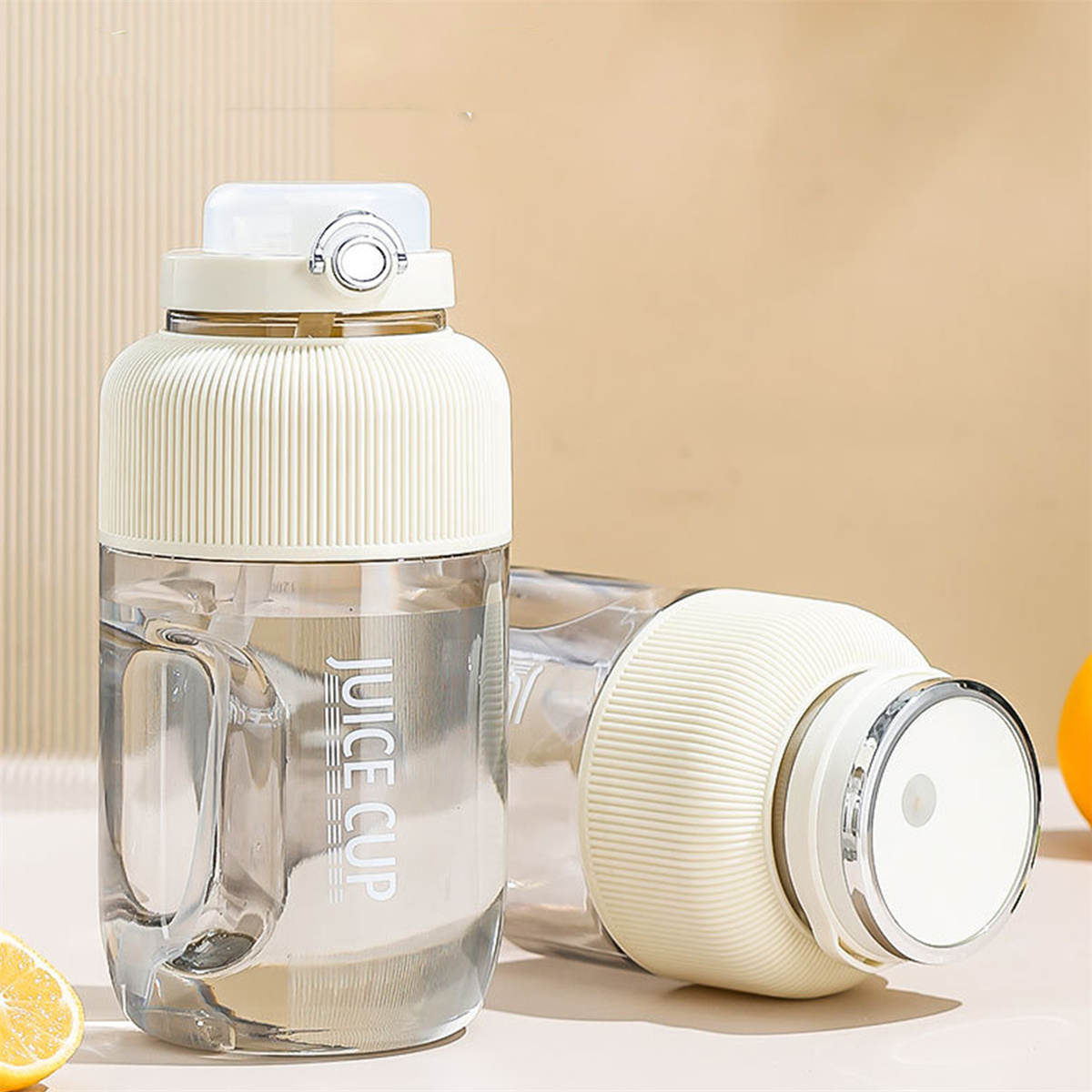 Zwei klare Wasserflaschen. Eine aufrecht, eine liegend mit der Aufschrift 'JUICE CUP'.