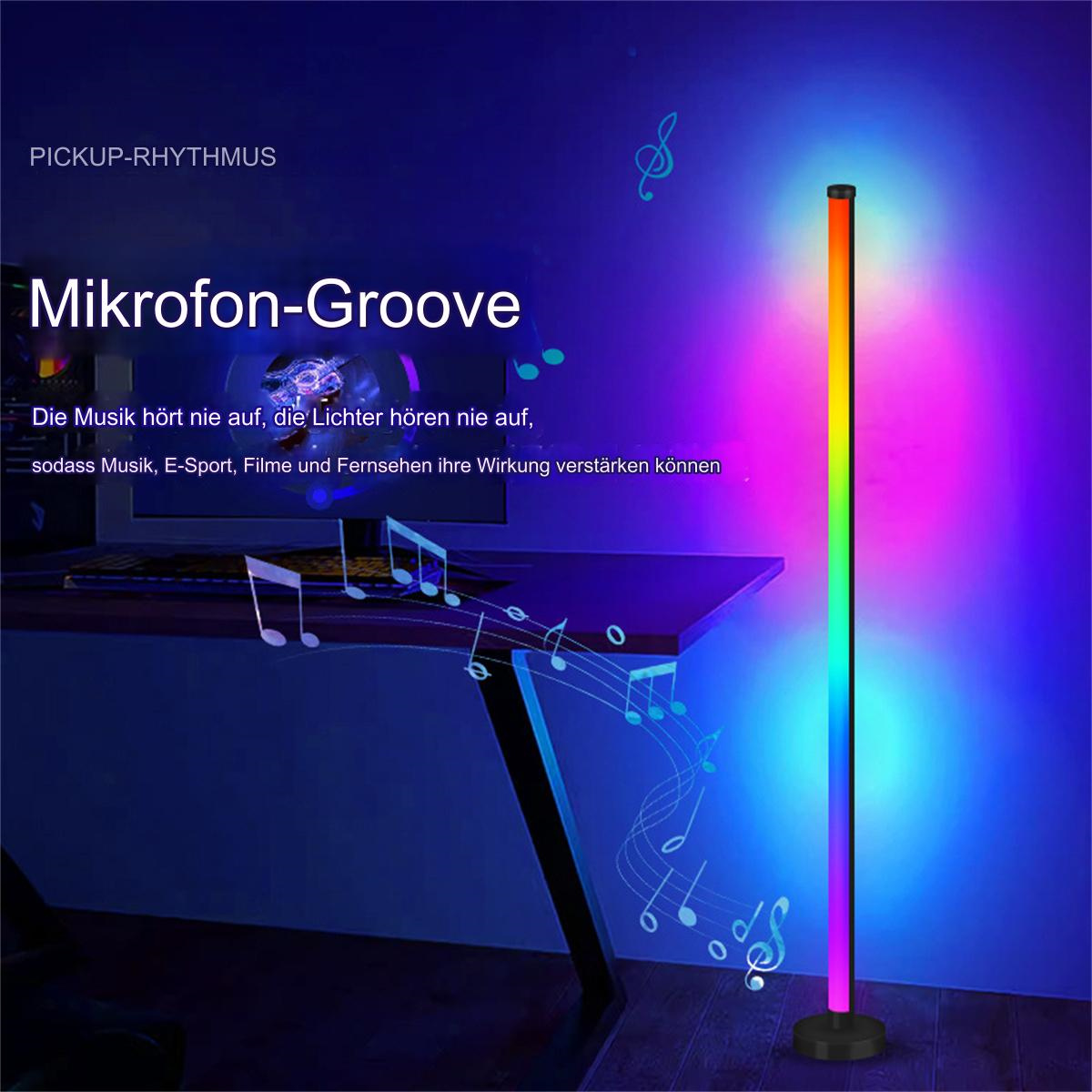 Eine hohe Stehlampe mit Farbverläufen, neben einem Schreibtisch platziert. Die Lampe hat eine Mikrofon-Groove-Funktion.