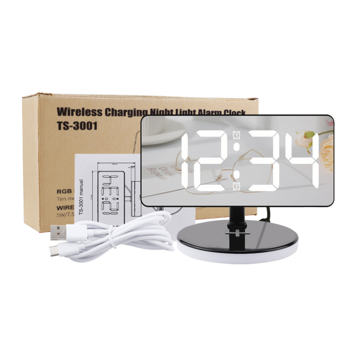 Digitaler Wecker mit weißer Anzeige. Box, Anleitung und USB-Kabel links. Weißer Hintergrund.