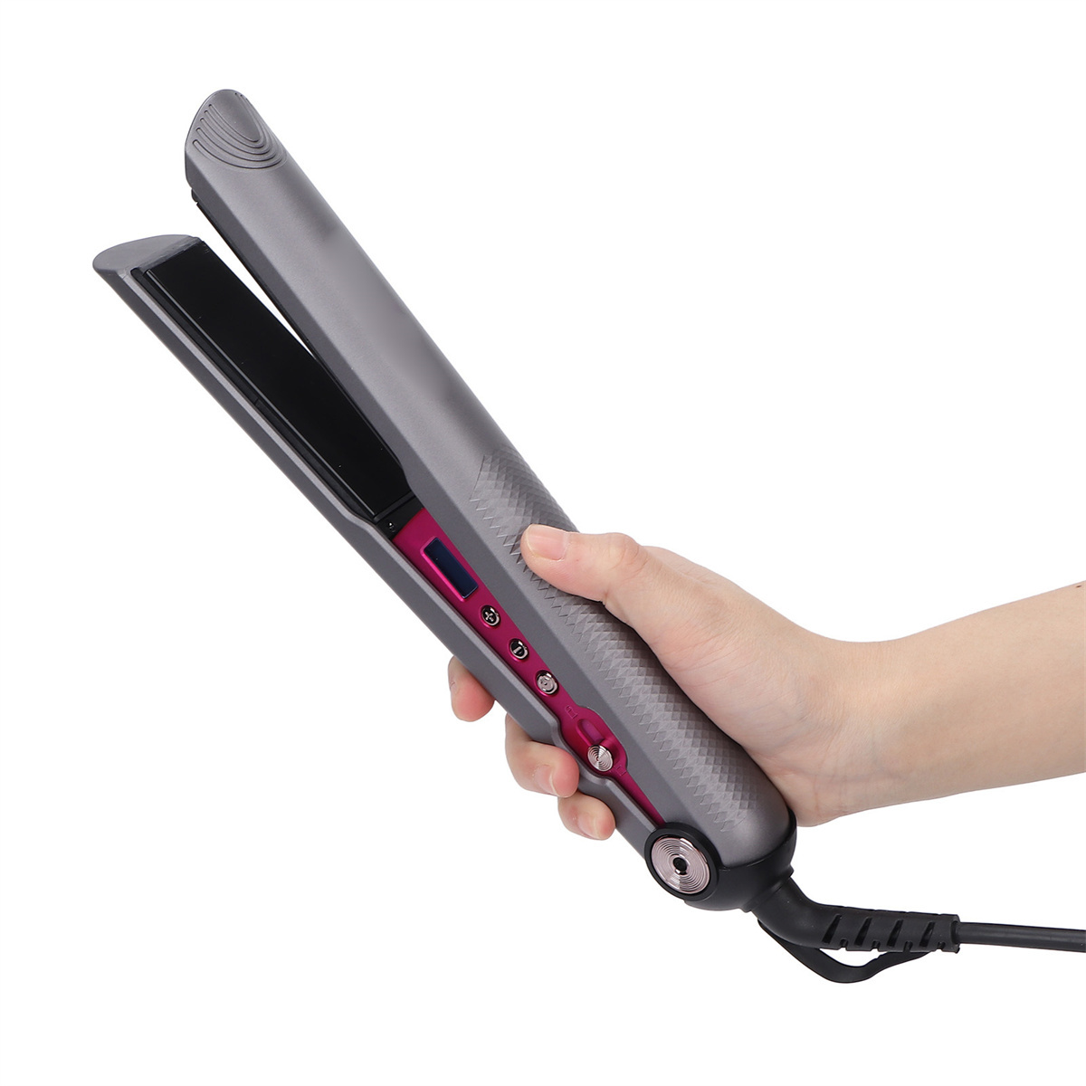 Ein grauer Haarglätter mit rosa Akzenten, der in einer Hand gehalten wird. Weißer Hintergrund.