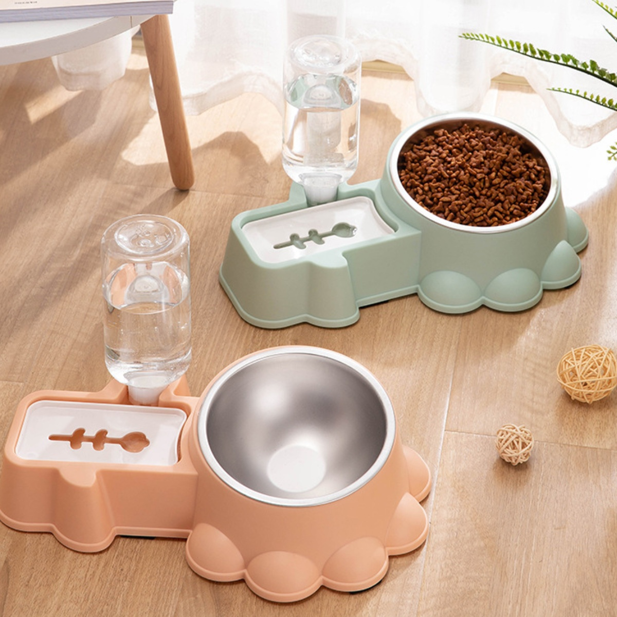 Zwei Futternäpfe mit Wasserspendern. Einer ist pfirsichfarben und der andere mintgrün.