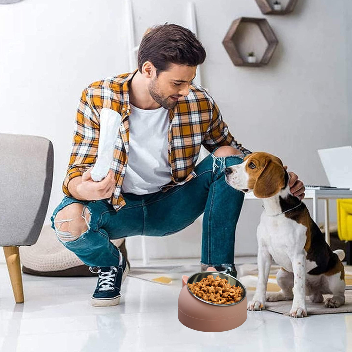 Ein Mann kniet neben einem Hund, beide schauen auf einen Napf mit Hundefutter in einer rosa Schüssel.