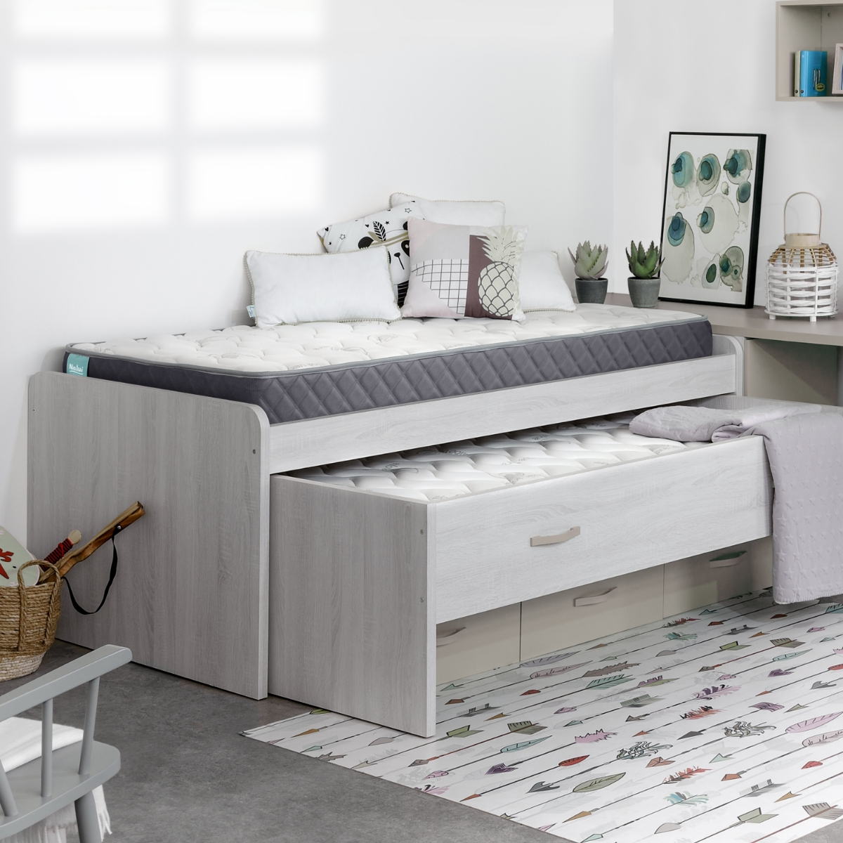 Escena de dormitorio con cama de dos niveles. Nivel superior con colchón, nivel inferior con cama extraíble.