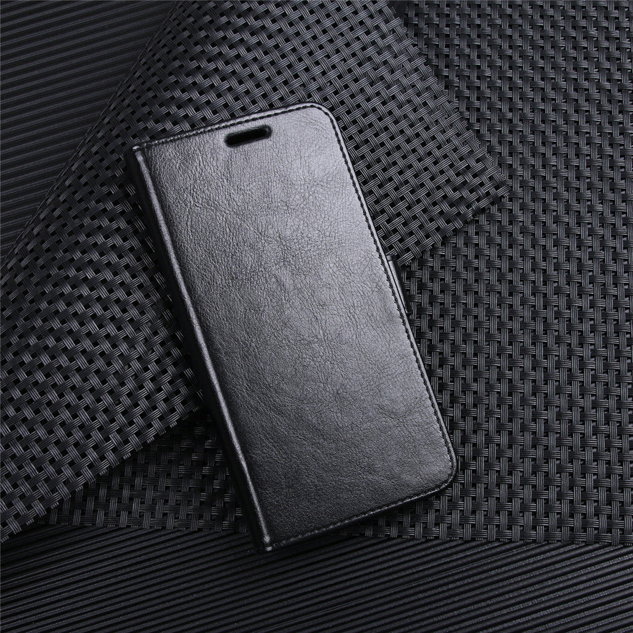 Coque de téléphone noire fermée, fond noir texturé.