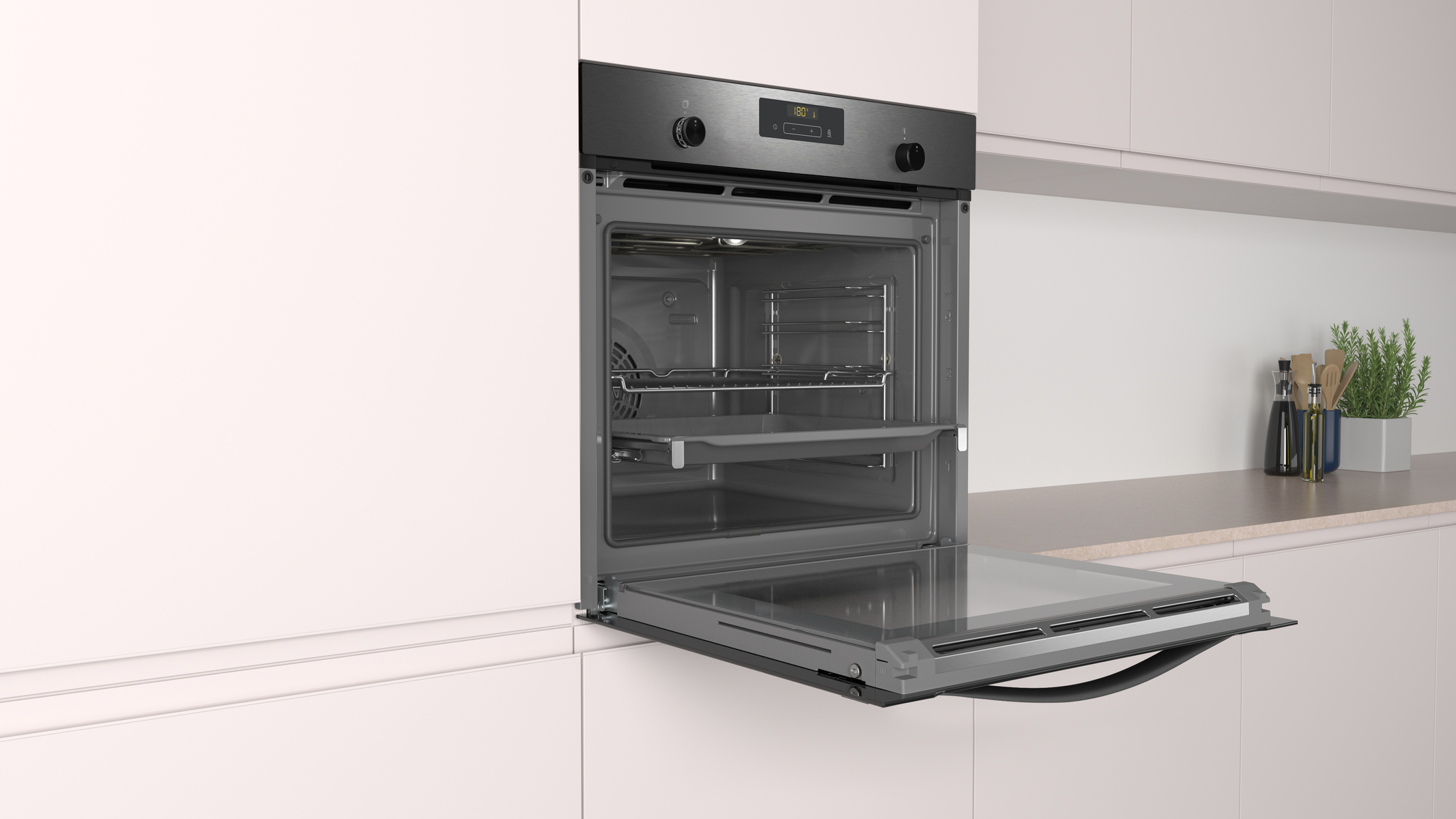 Horno empotrado con la puerta abierta. El interior tiene estantes y una luz. En una cocina blanca.