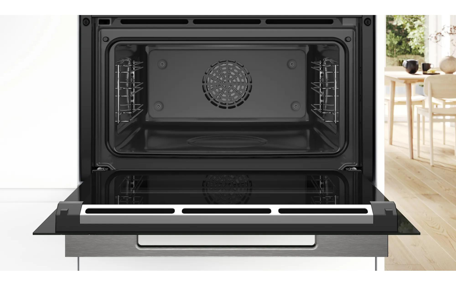 Open oven met de deur op een kier. Binnenaanzicht van de ovenholte. RVS handvat en deurafwerking. Witte kasten.
