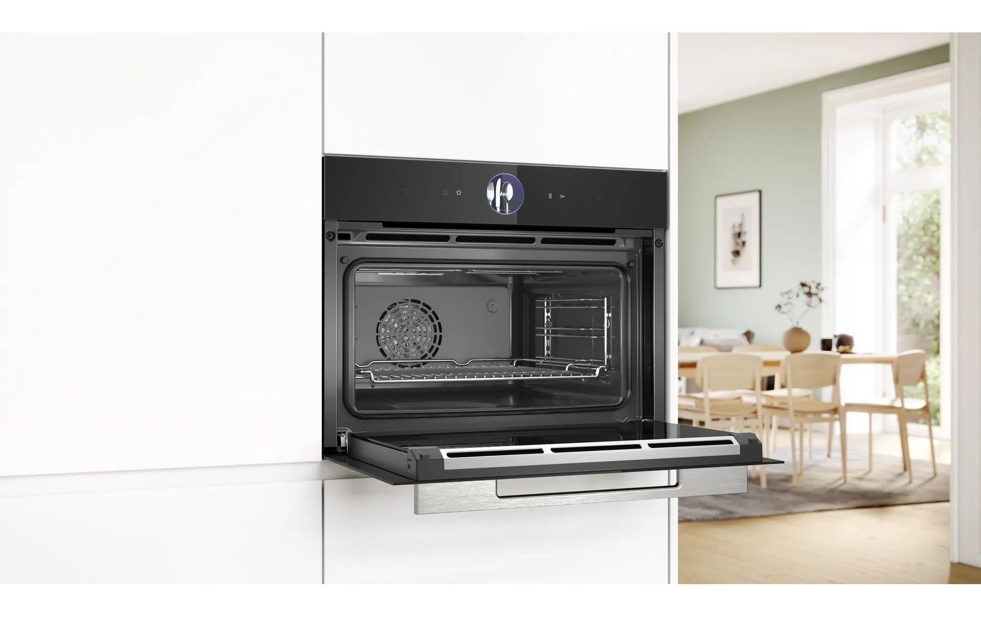 Open oven, ingebouwd. Keuken met eethoek zichtbaar op de achtergrond.