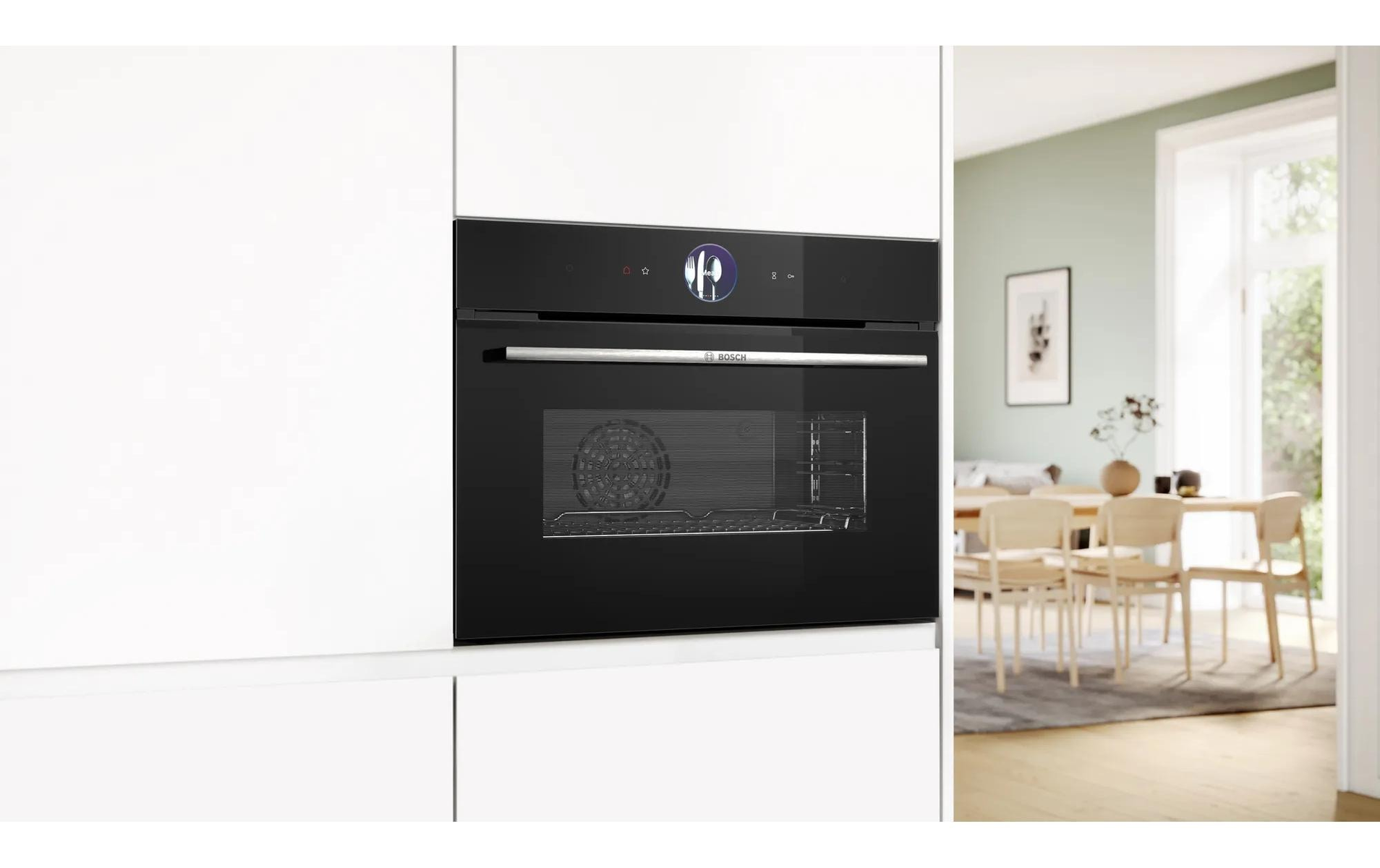 Oven geïnstalleerd in een witte keuken. Zwart front en display, met een eethoek op de achtergrond.