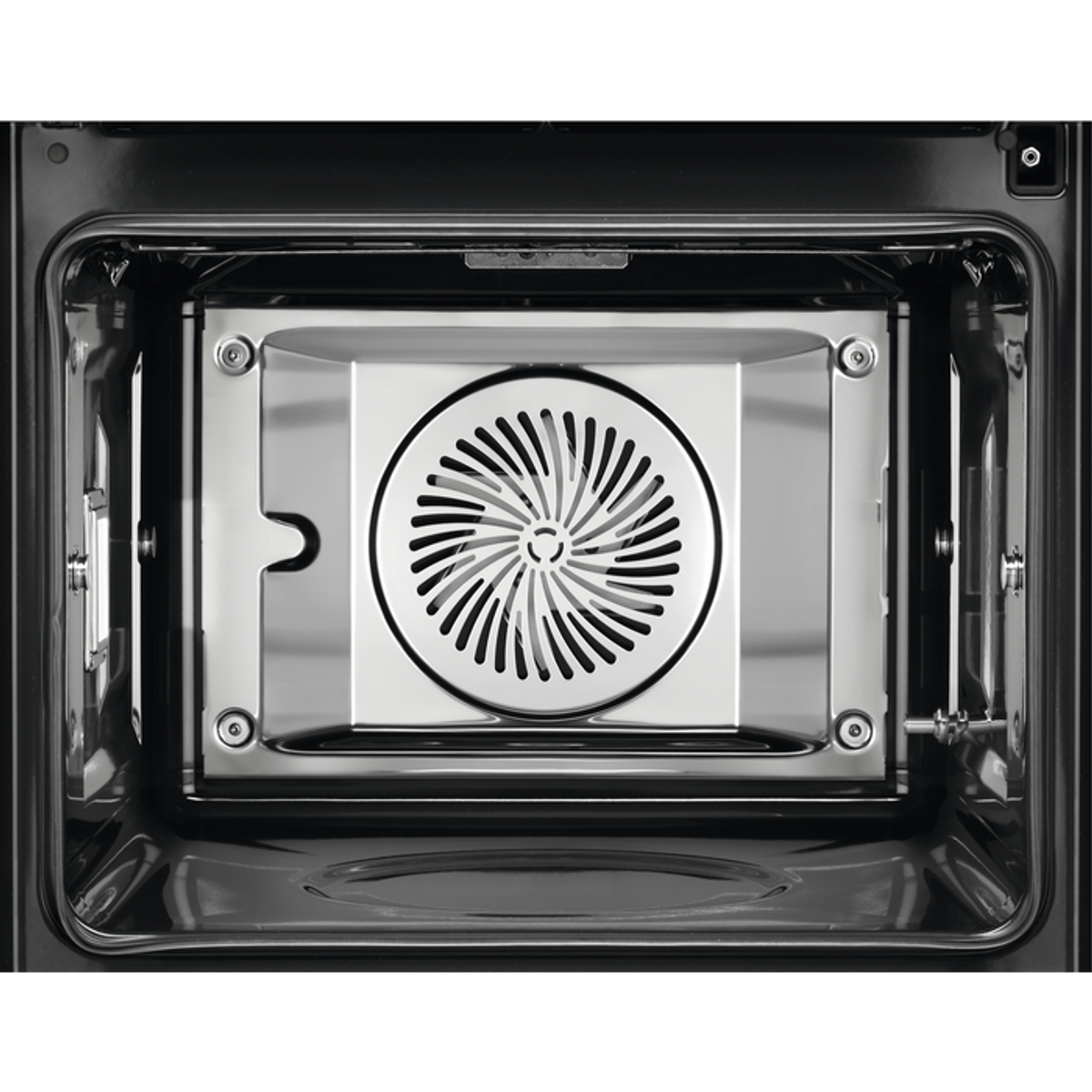 Close-up of oven interior. Black interior with a fan at the back. Metal and black elements.
