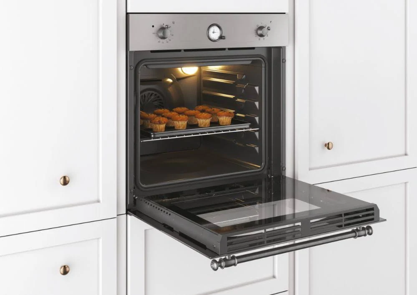 Un forno con la porta aperta, che rivela muffin su una griglia all'interno di un interno luminoso e pulito.