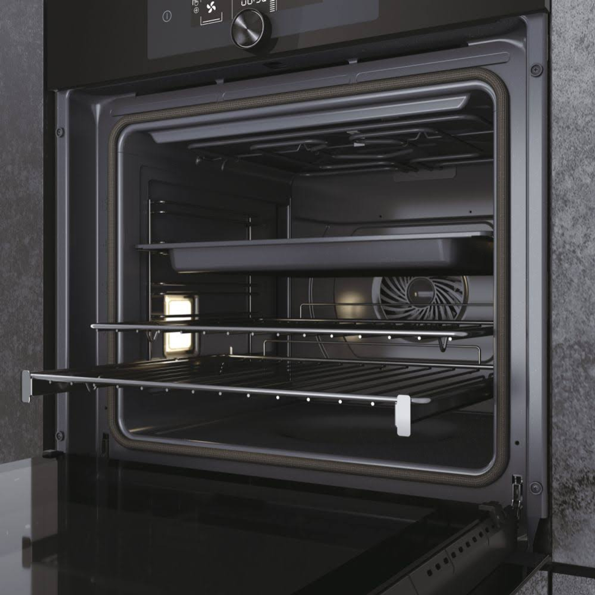 Interno del forno aperto con griglie e ventola. Interno nero.