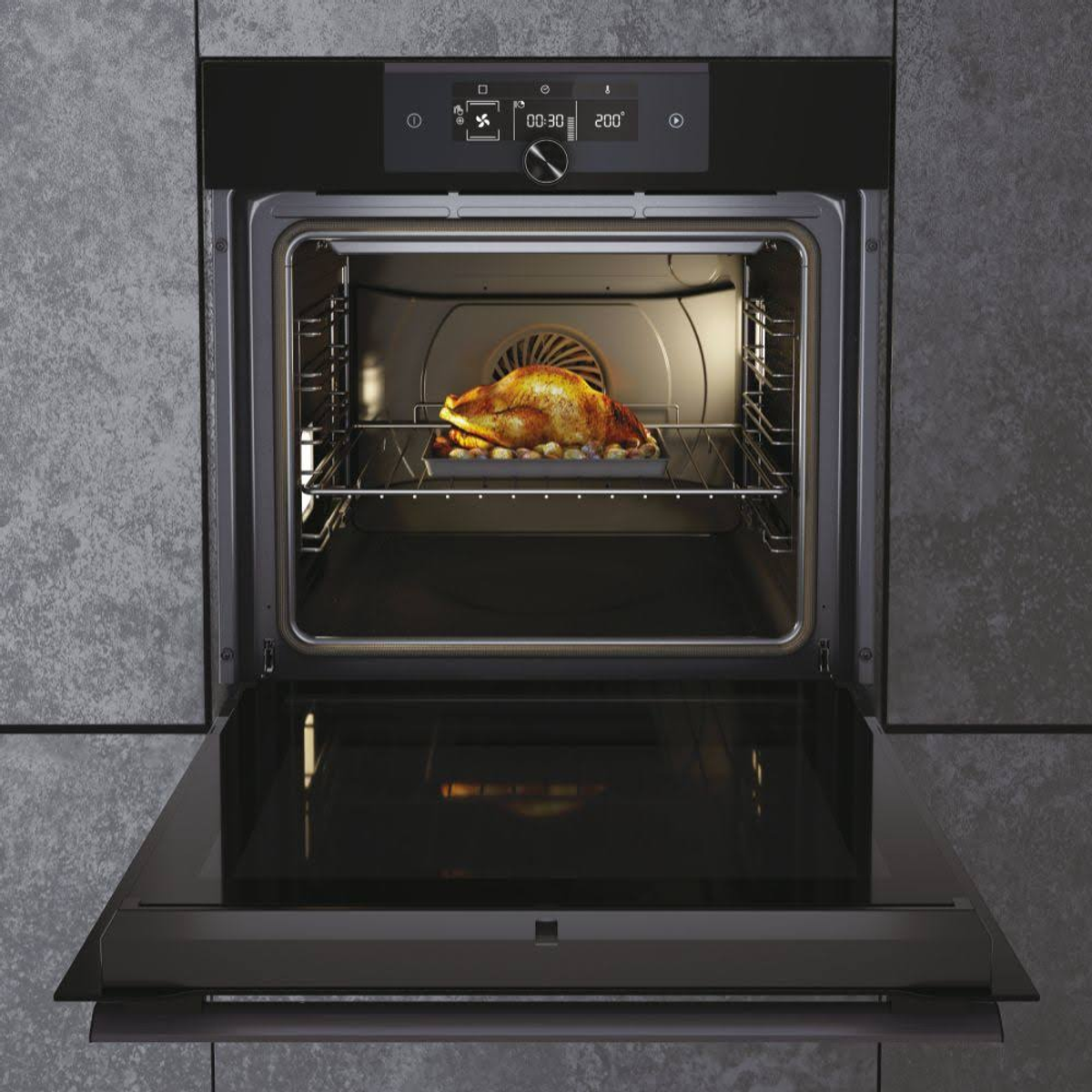 Un forno nero con un pollo cotto su una griglia. La porta è aperta.