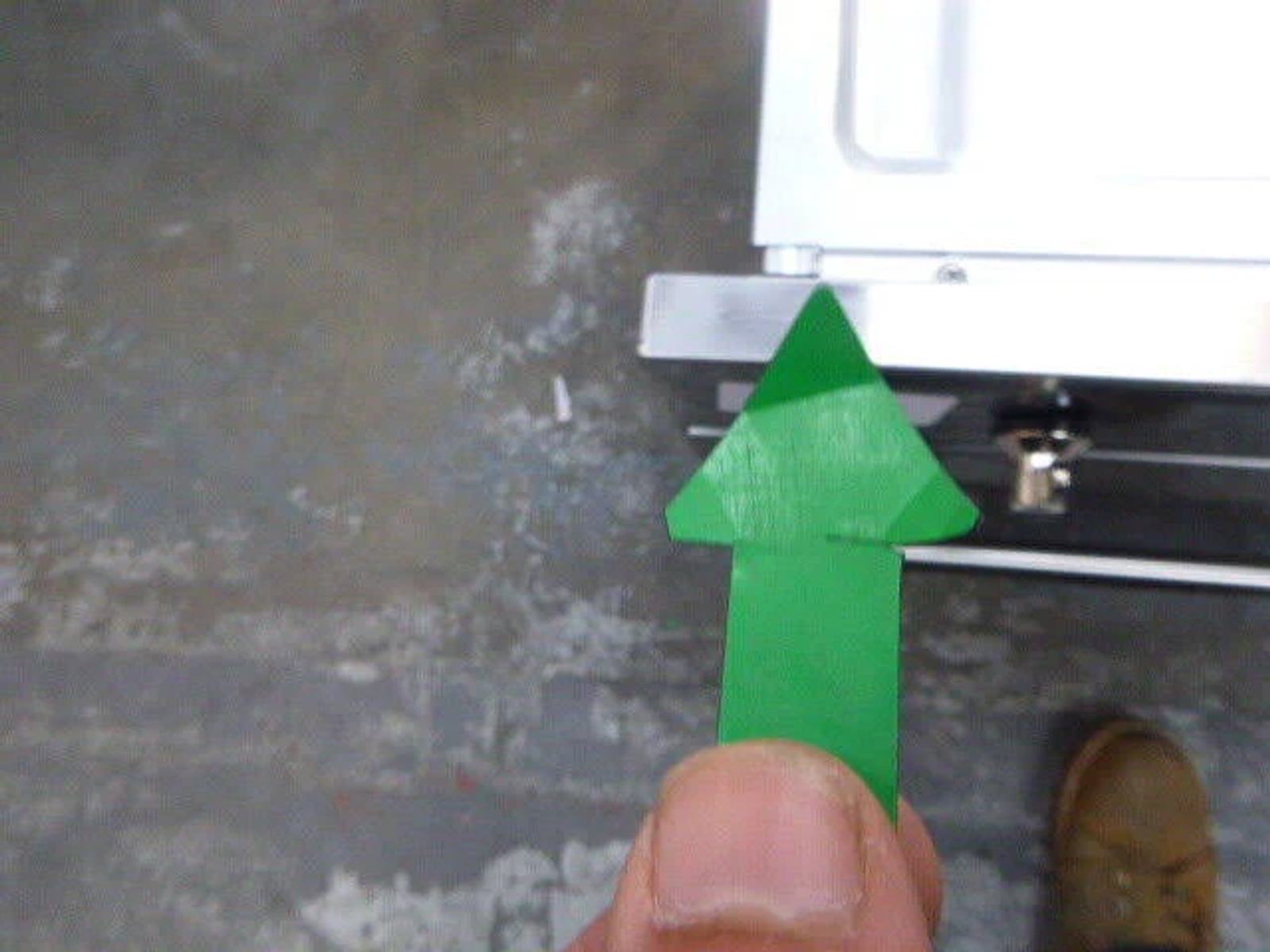 Una flecha verde que apunta hacia arriba, con un fondo gris y una mano que la sostiene.