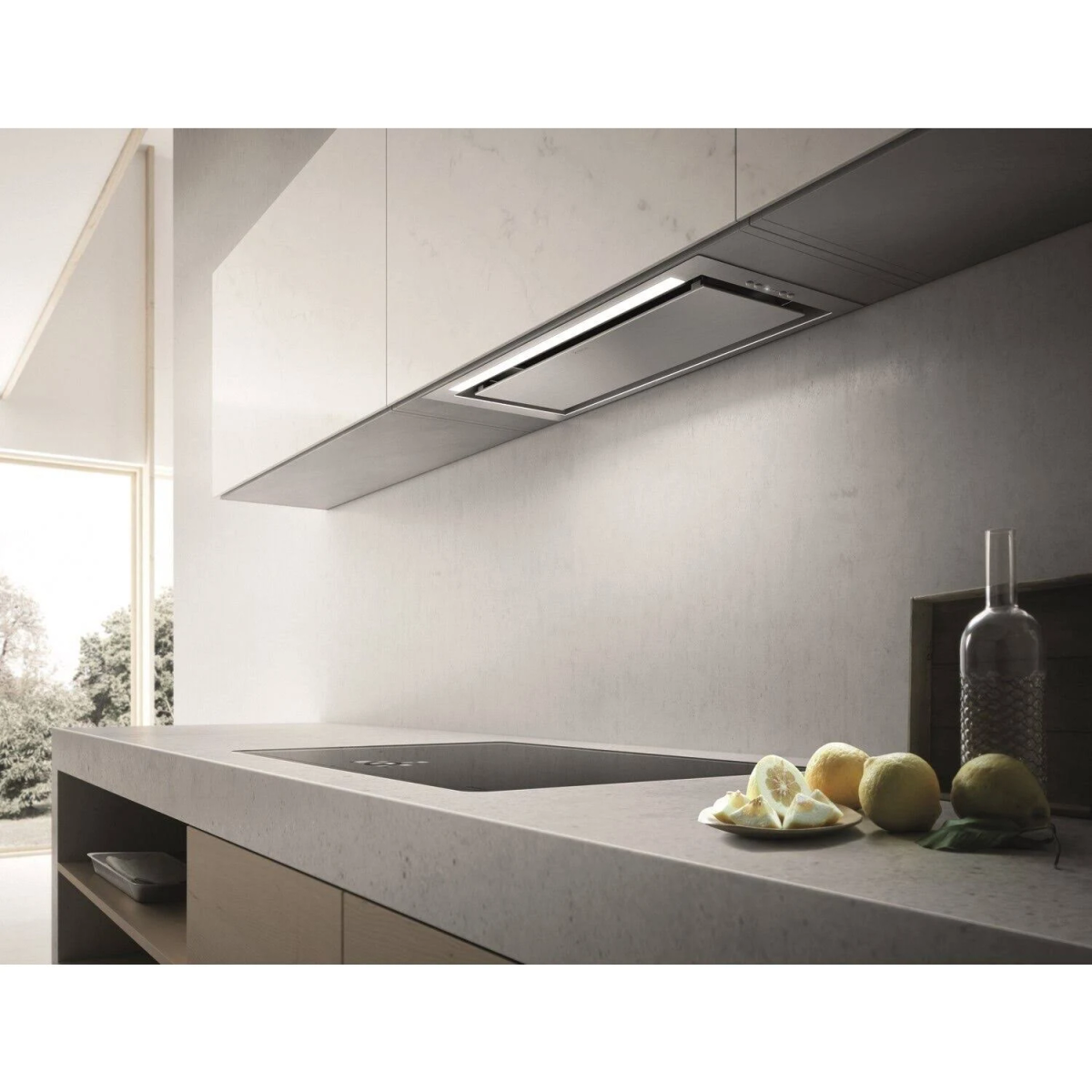 Una scena di cucina moderna con un piano di lavoro, limoni e una cappa aspirante sopra. Minimalista e luminoso.
