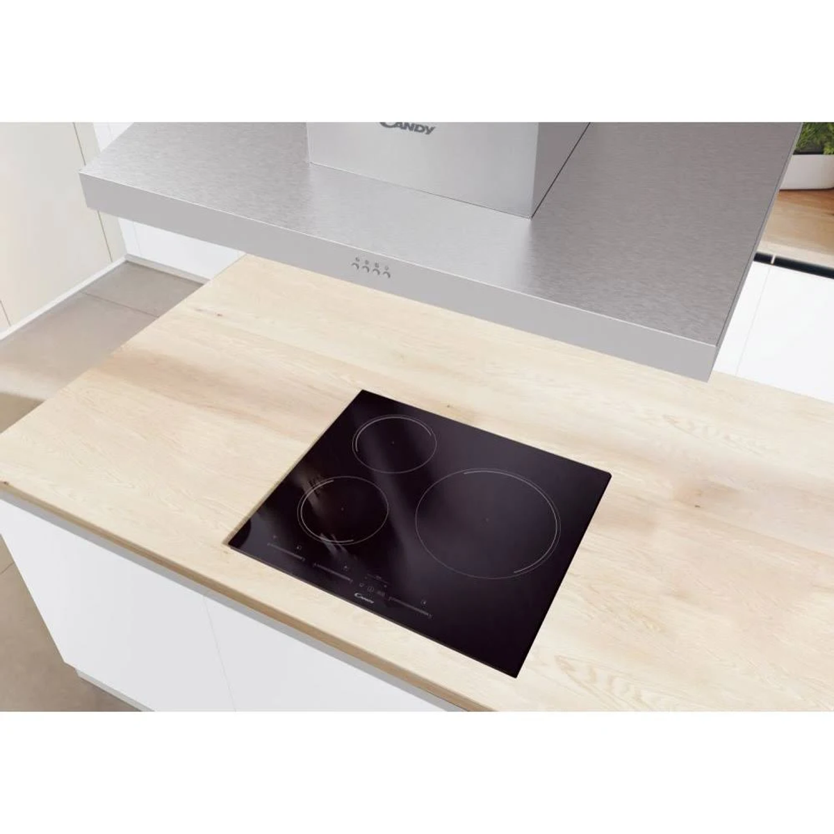 Piano cottura in vetroceramica nero con tre zone cottura e cappa in acciaio inox sopra.