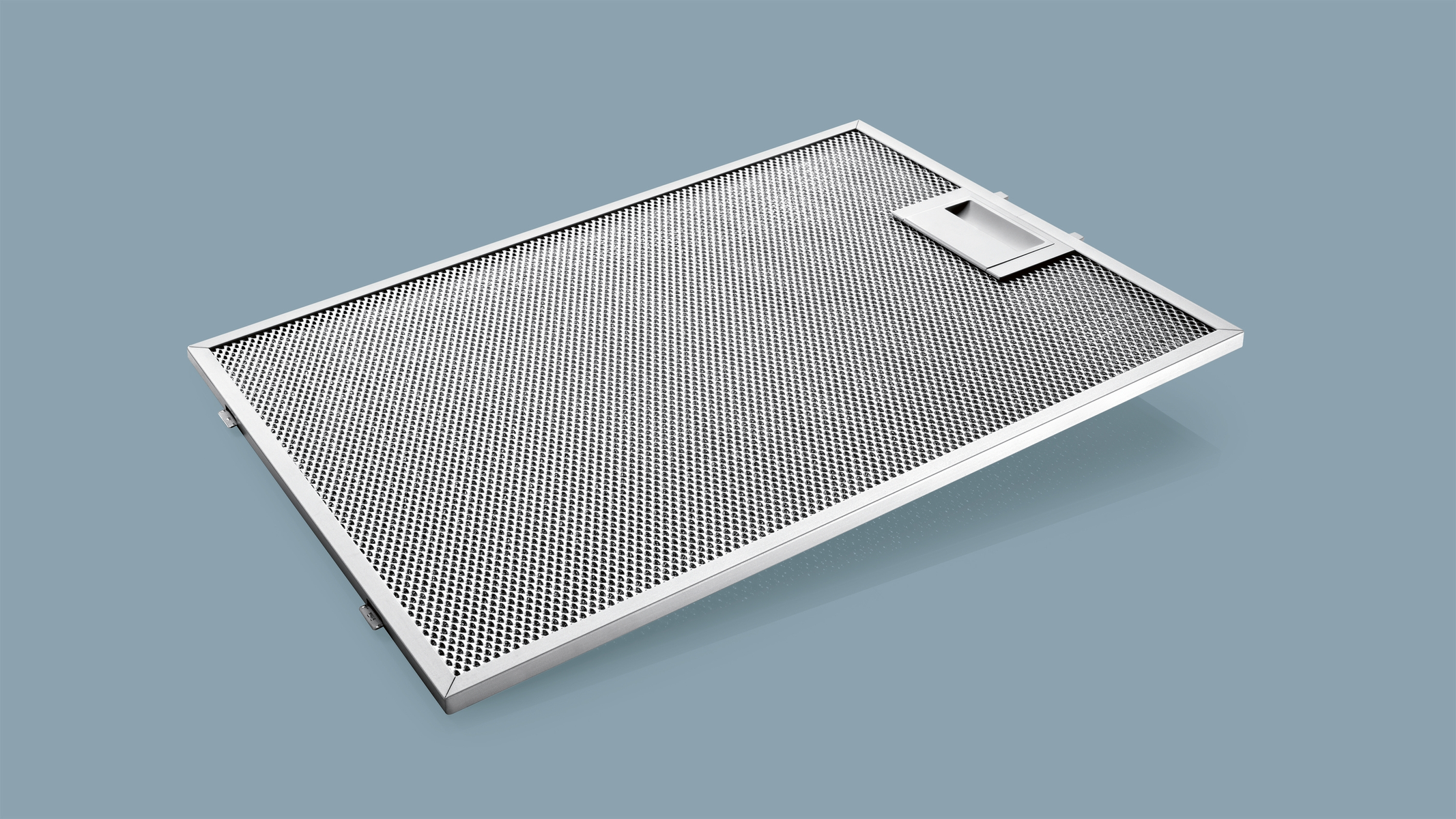 Filtr ze stali nierdzewnej, z perforowanymi otworami, na szarym tle.