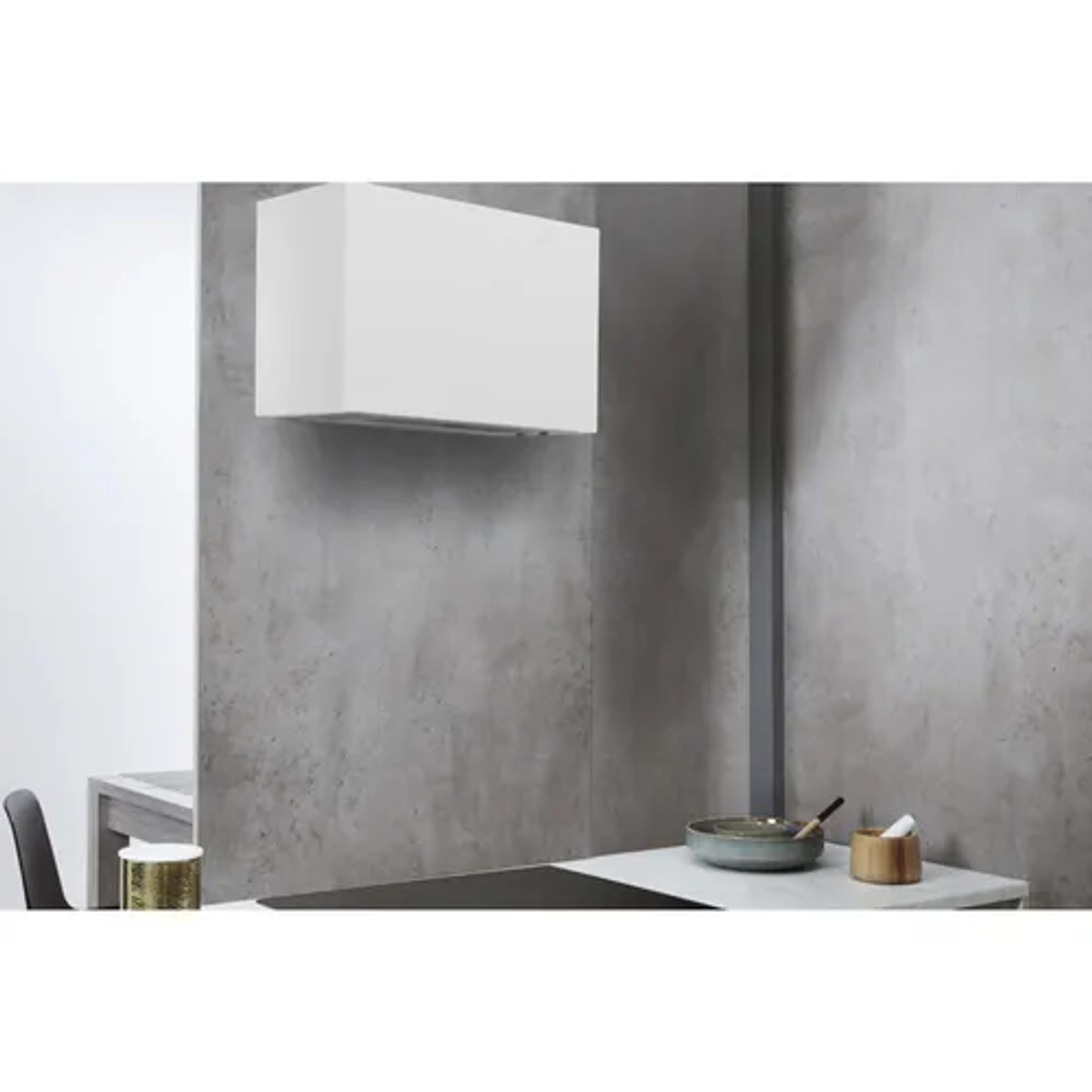 Biały okap zamontowany na szarej ścianie. Widoczny jest blat kuchenny.