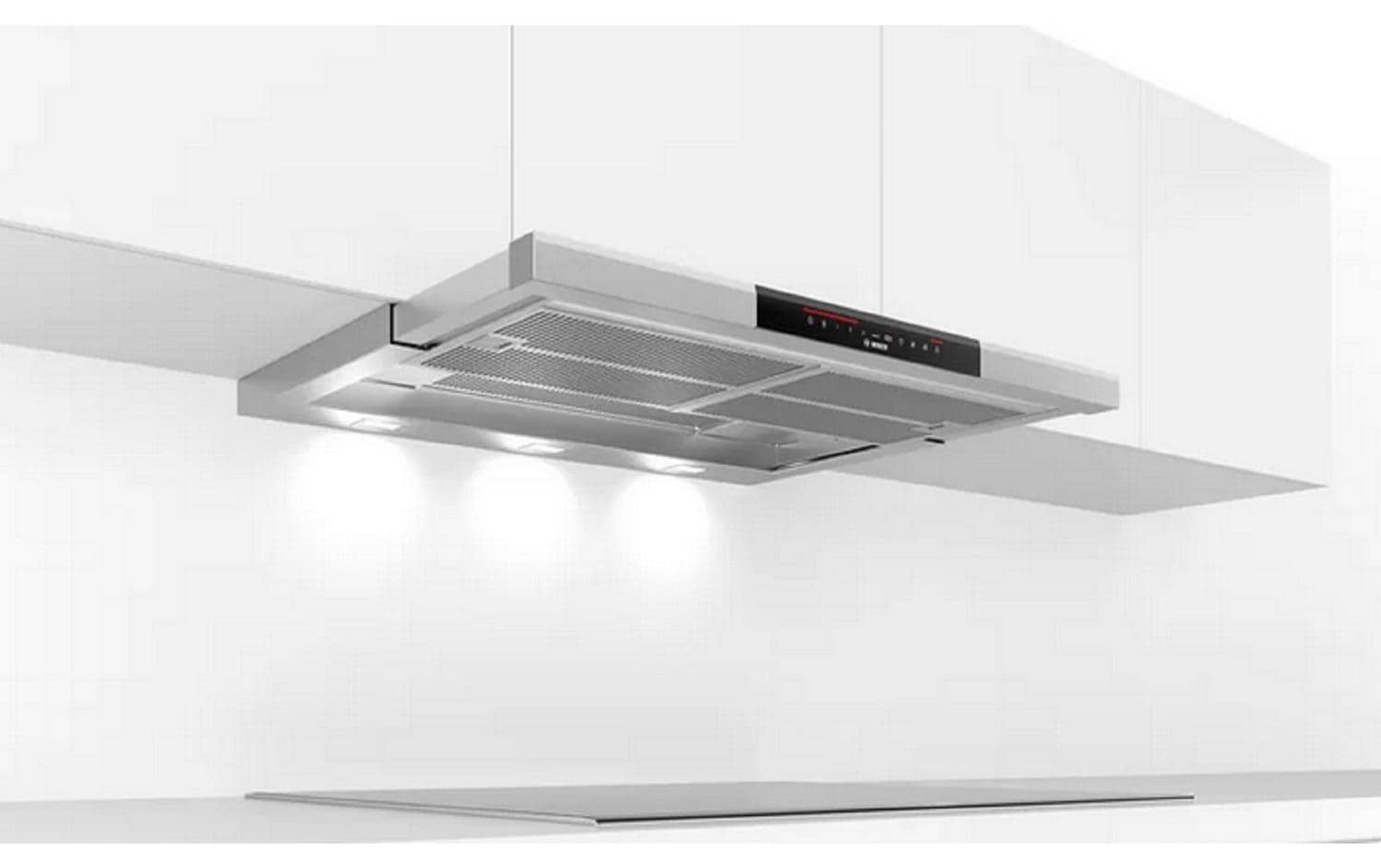 Cocina moderna con campana extractora de acero inoxidable. La cocina es blanca con luces empotradas.