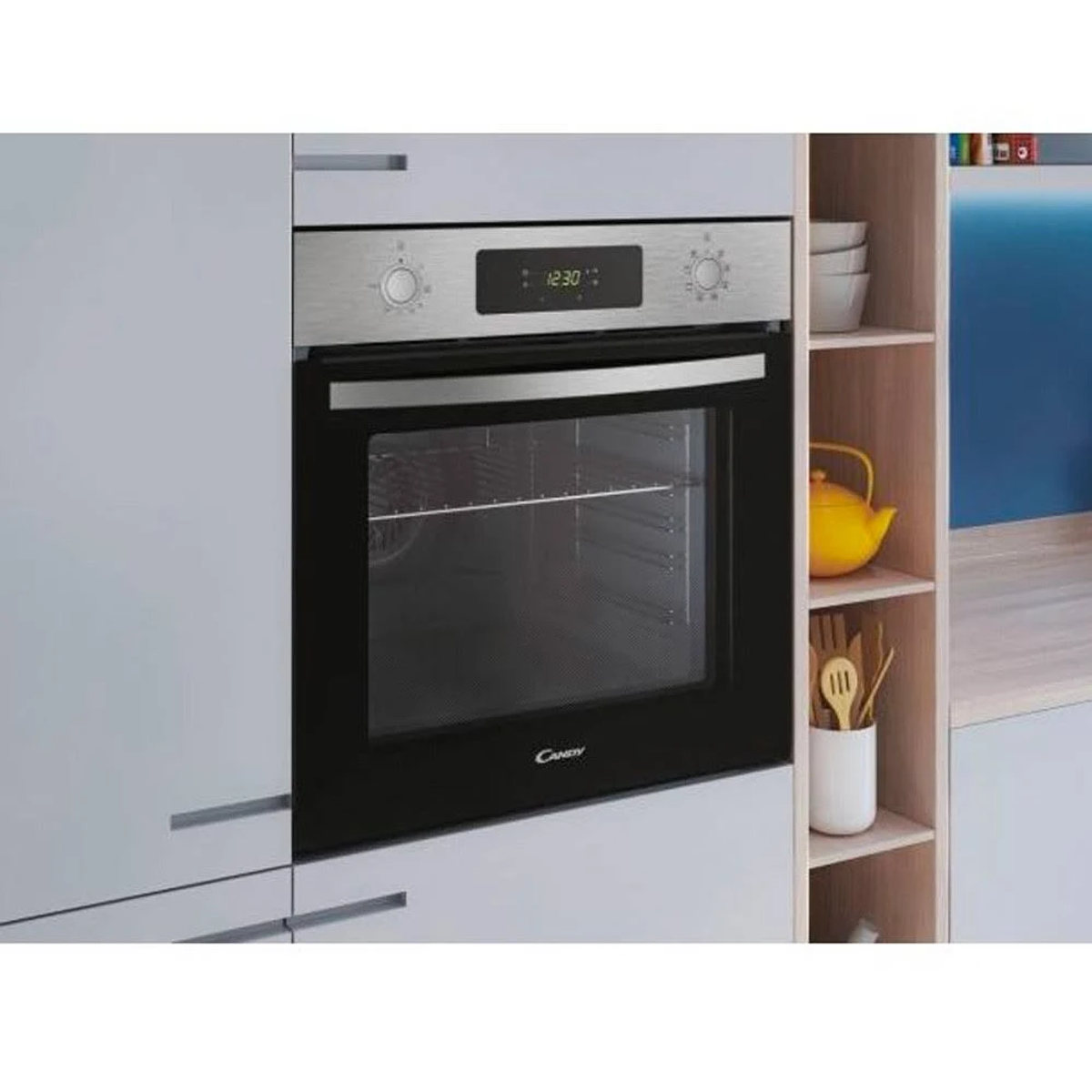 Forno in ambiente cucina: forno Candy, frontale in acciaio, orologio digitale, cucina bianca.