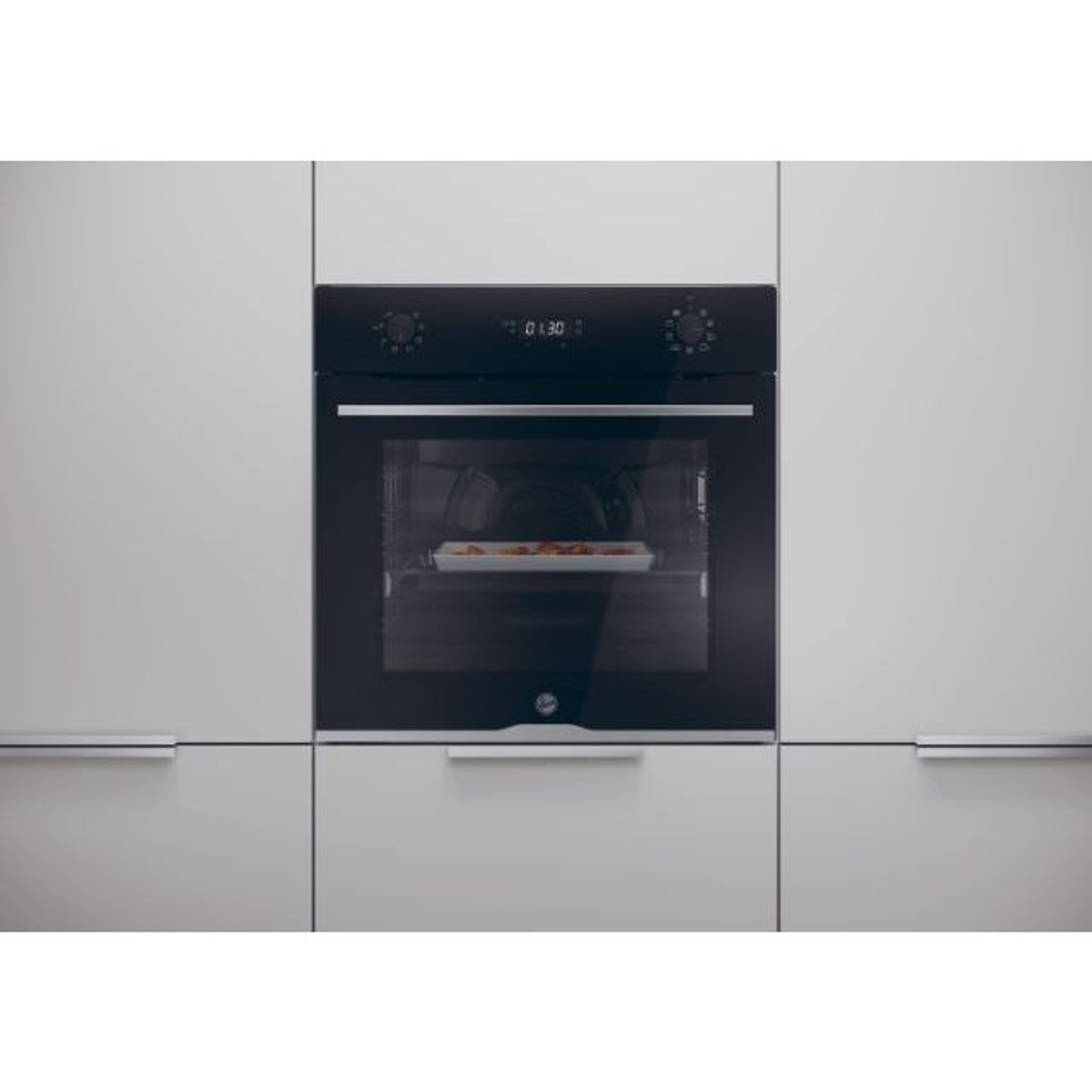 Forno integrato in un mobile da cucina. Porta aperta, con cibo all'interno, pannello nero.