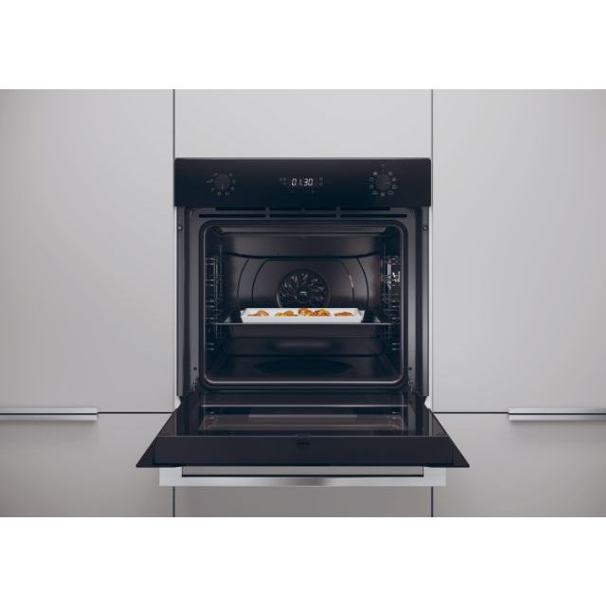 Forno nero aperto con un vassoio di cibo all'interno. Sfondo grigio.